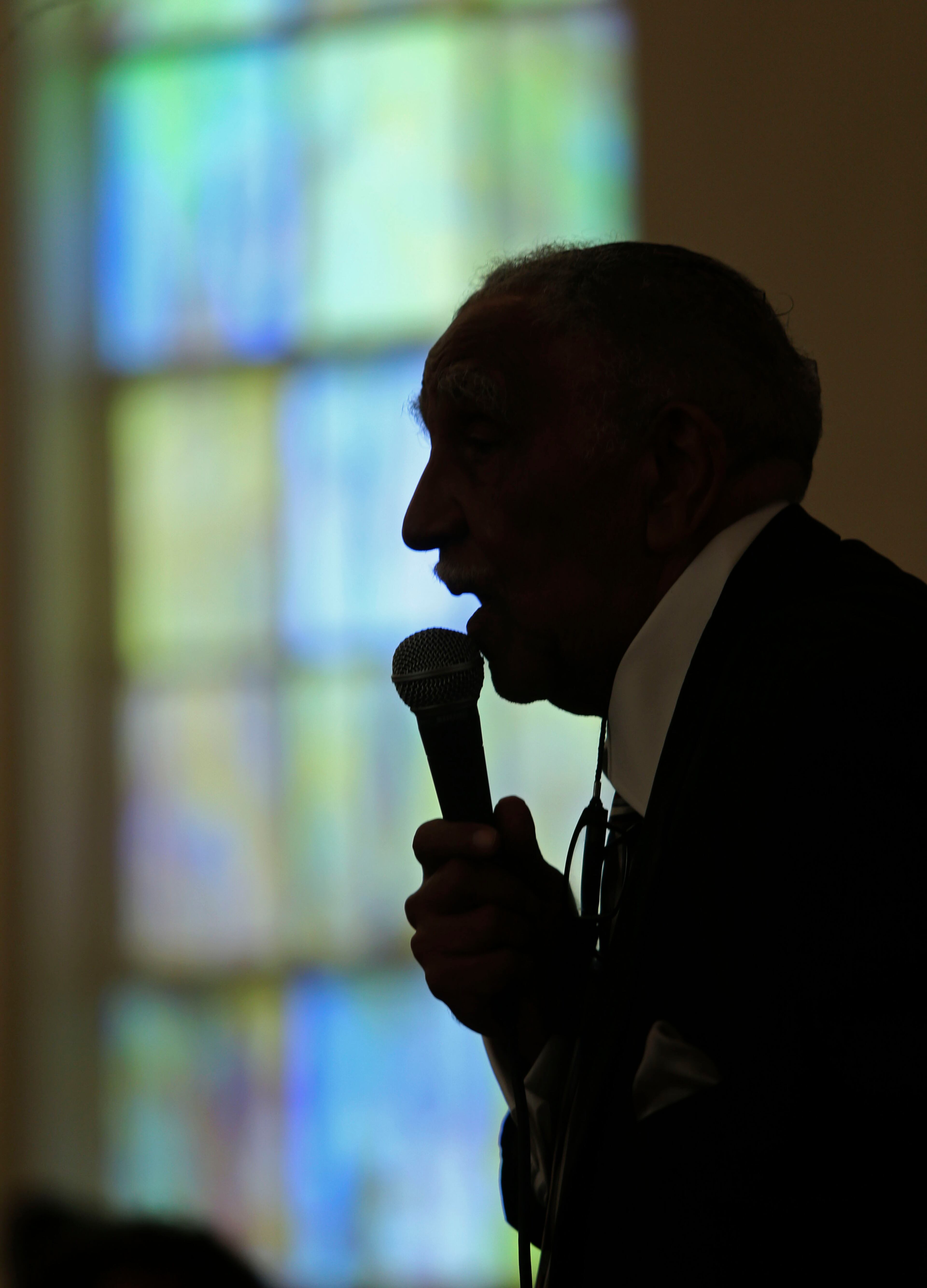 The silhouette of Rev. Joseph Lowery is shown as he speaks during a prayer vigil in 2014 in Atlanta. PHOTO / JASON GETZ