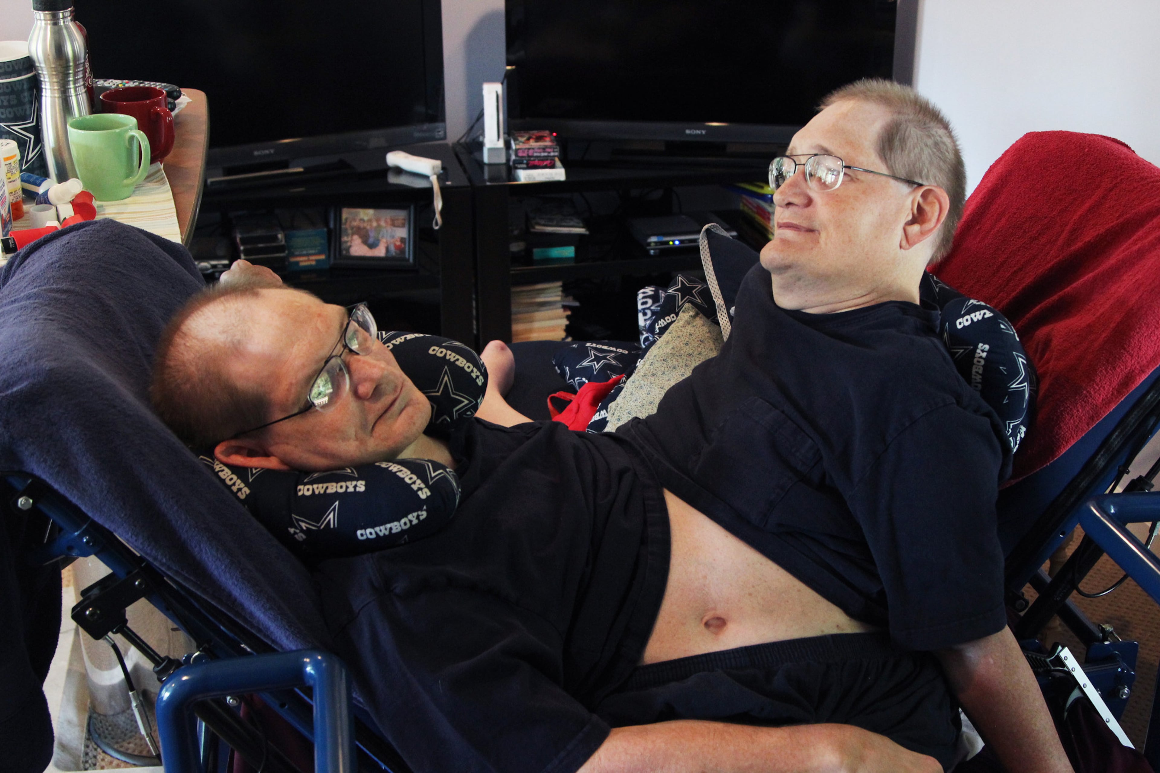 Donnie, left, and Ronnie Galyon sit inside their Beavercreek, Ohio, home, Wednesday, July 2, 2014. Donnie and Ronnie are nearing the record for longest living conjoined twins. The Galyons, born Oct. 28, 1951 at St. Elizabeth Hospital in Dayton, now live in Beavercreek with their brother, Jim Galyon and his wife Mary, who provide 24-7 care for them. (AP Photo/The Daily News, Drew Simon)