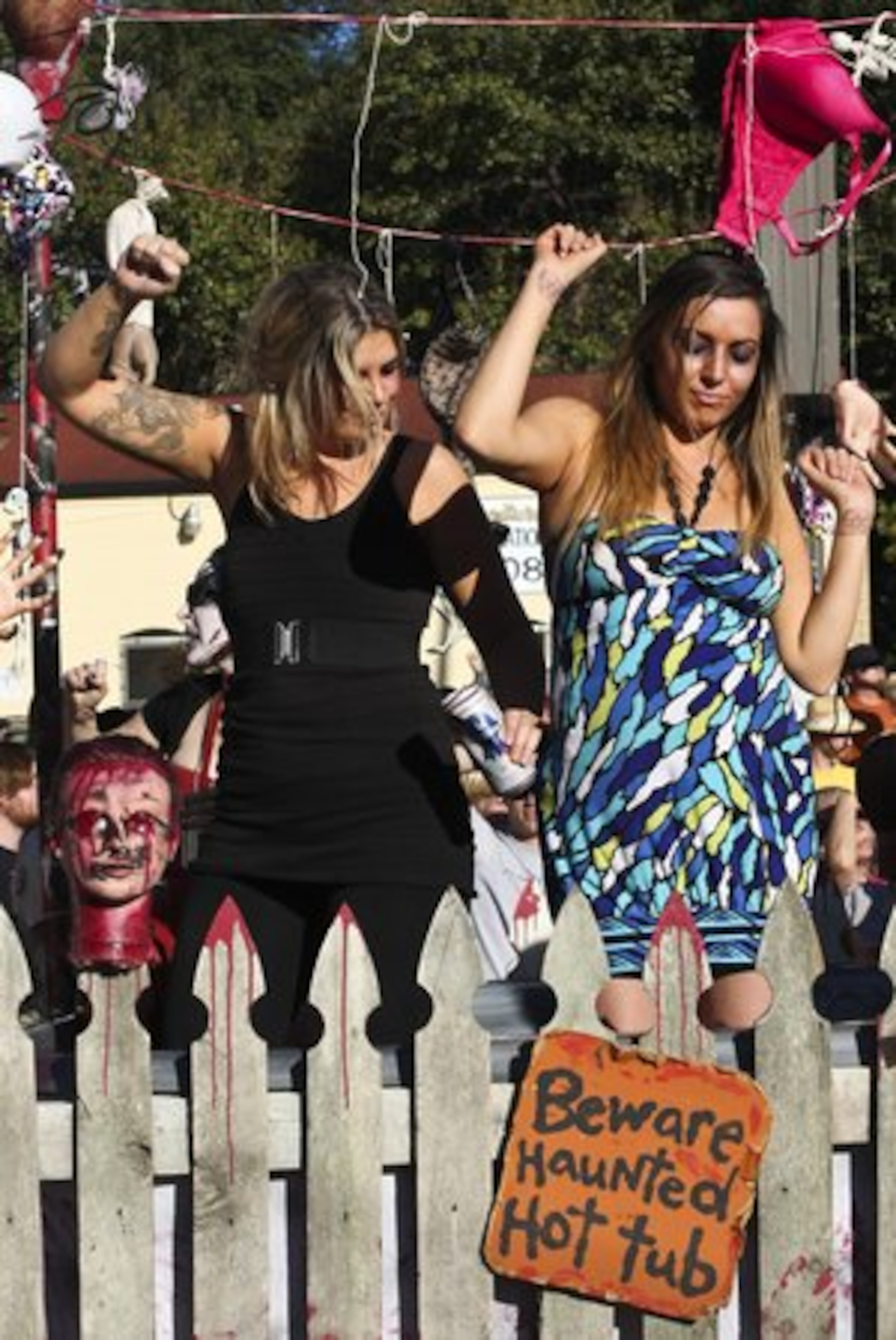 Parade participants groove to the beat, not deterred by the haunted hot tub sign.