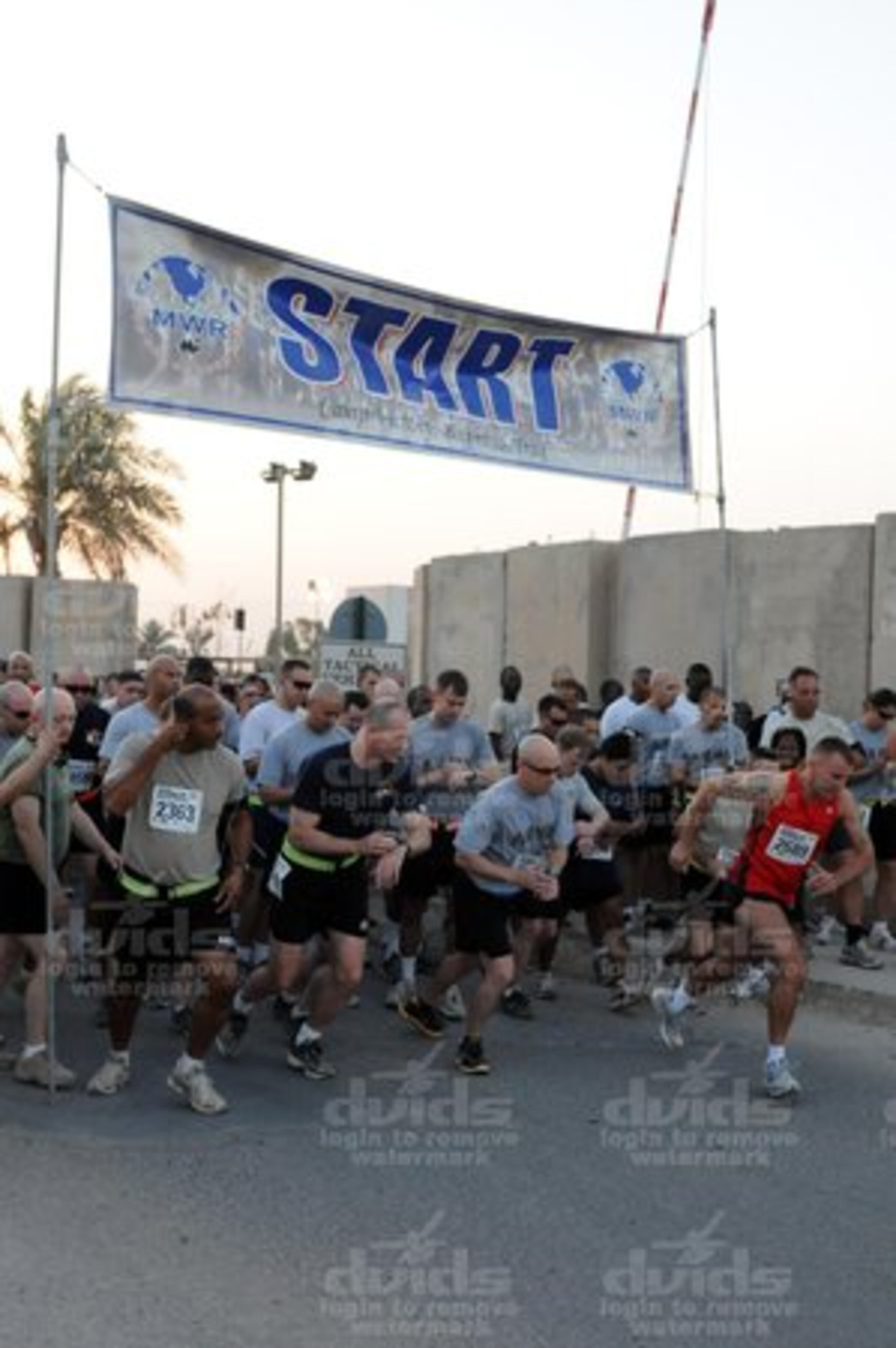 In Iraq, runners dash away from the starting line of the Atlanta Journal-Constitution Peachtree Road Race 10K shadow run sponsored by Baghdad Chief Petty Officers and Petty Officers Association at Camp Victory July 4. This "shadow" race was held in conjunction with the race in Atlanta.