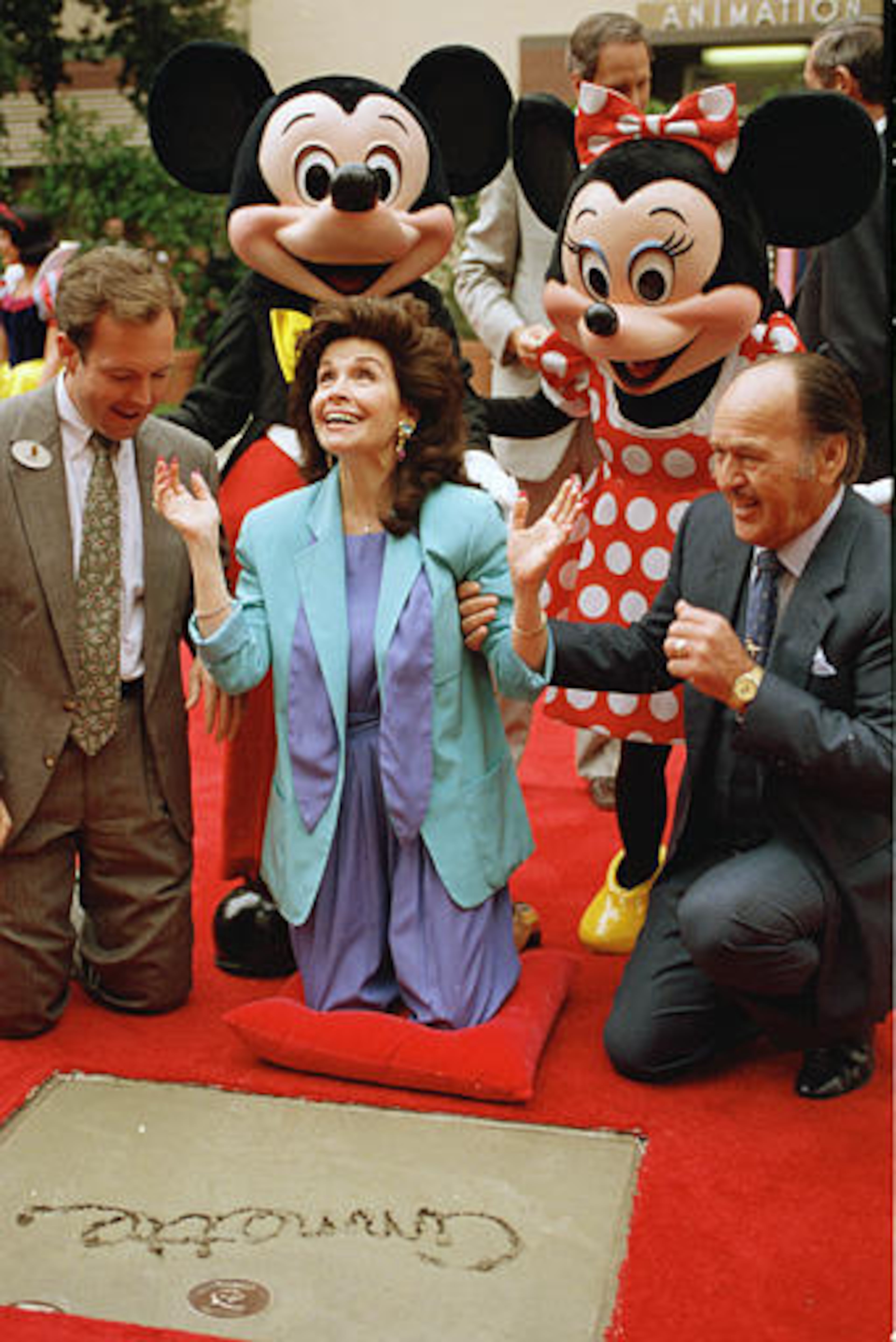 Former "Mouseketeer" Annette Funicello gets set to put her hands in the cement at Walt Disney Studios Theatre, in Burbank, Calif., as she is honored with the Disney Legend Award, on October 21, 1992. With Funicello is her husband Glen Holt, right, and Jeff Hofman, left, Disney Studios official. (AP Photo/Nick Ut)