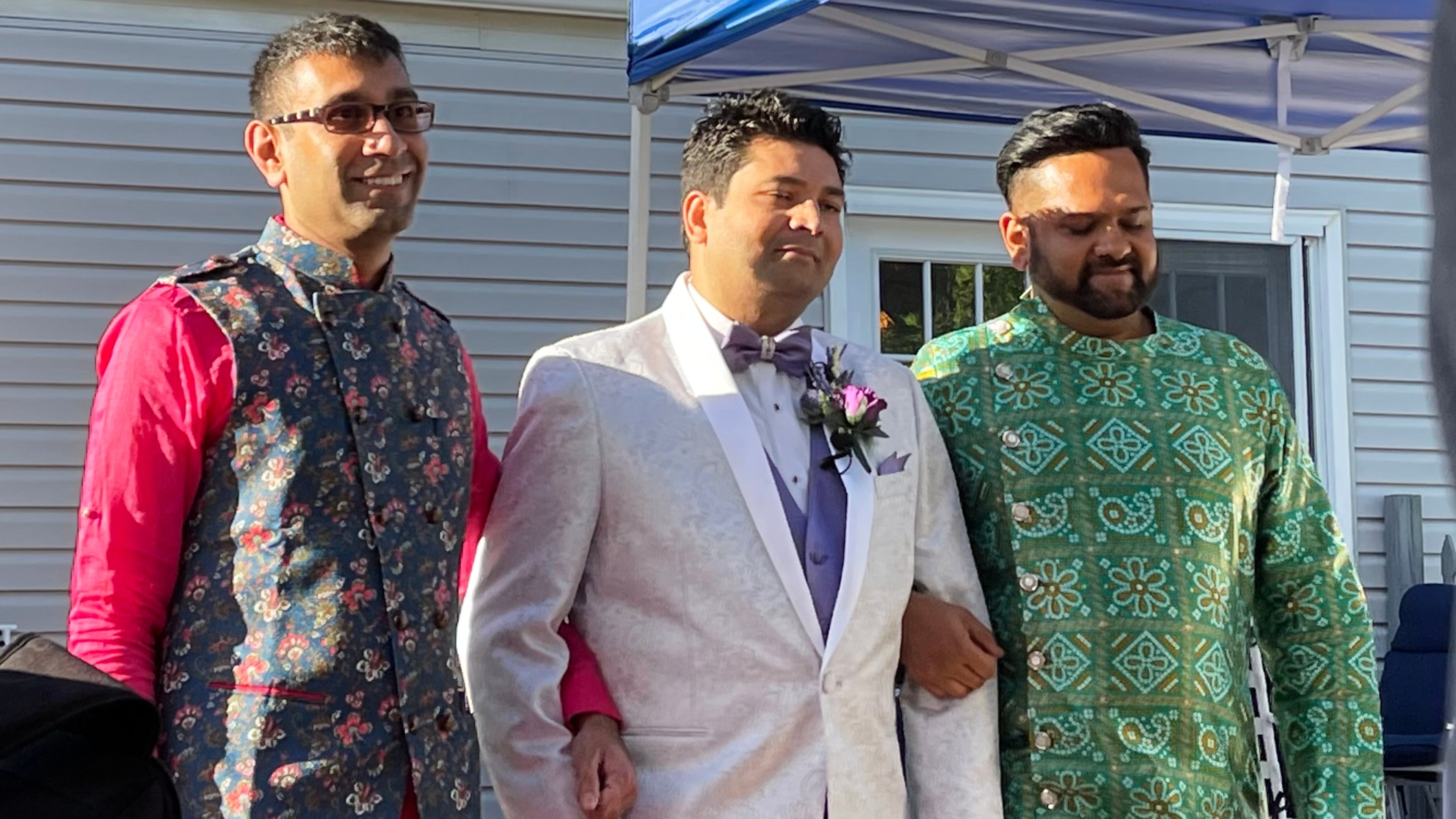 This photo provided by Jolene Gosha shows Venus Patel, left, walking his friend, Pratik Jhaveri, center, down the wedding aisle in Collinsville, Ill., June 18, 2022. CORRECTION: Corrects Jolene's surname from Gosh to Gosha. (Jolene Gosha via AP)