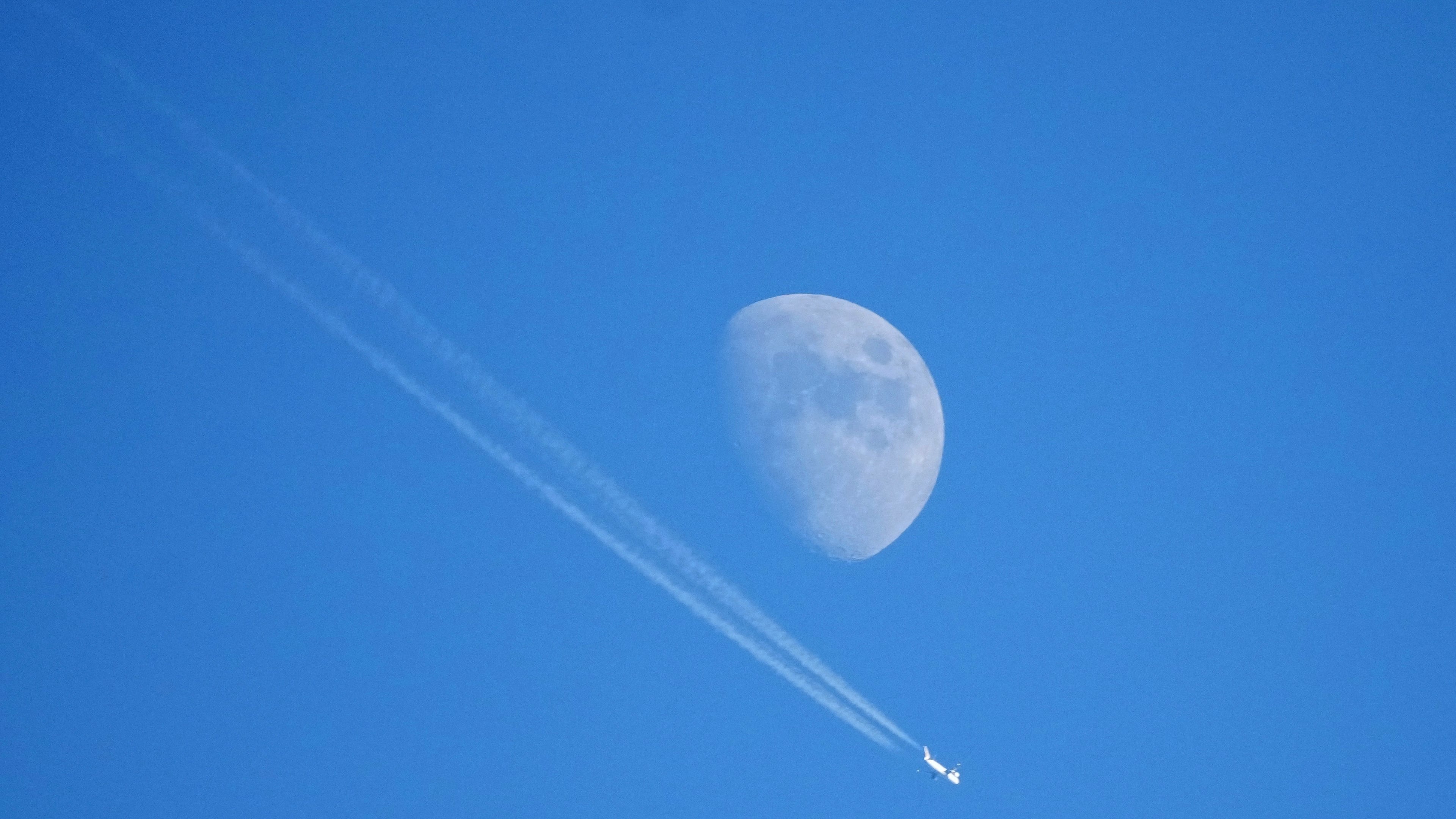 FILE - An airplane flies high in the sky with the moon in the background in Garmisch-Partenkirchen, Germany, Jan. 1, 2023. (AP Photo/Matthias Schrader, File)