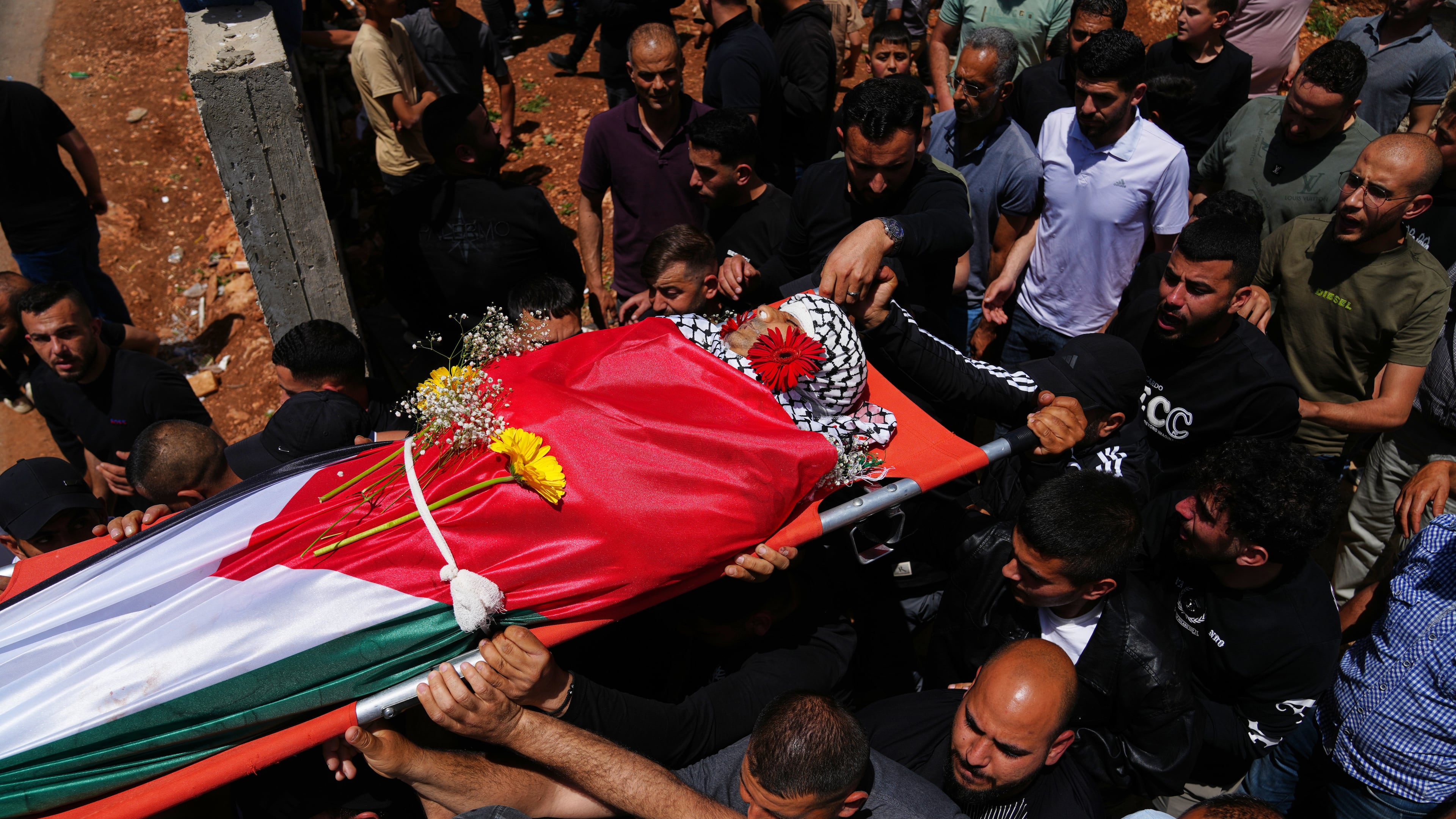 Mourners carry the body of Palestinian Zakaria Qatousa, during his funeral in the West Bank town of Deir Qaddis Wednesday, May 13, 2026. (AP Photo/Mahmoud Illean)