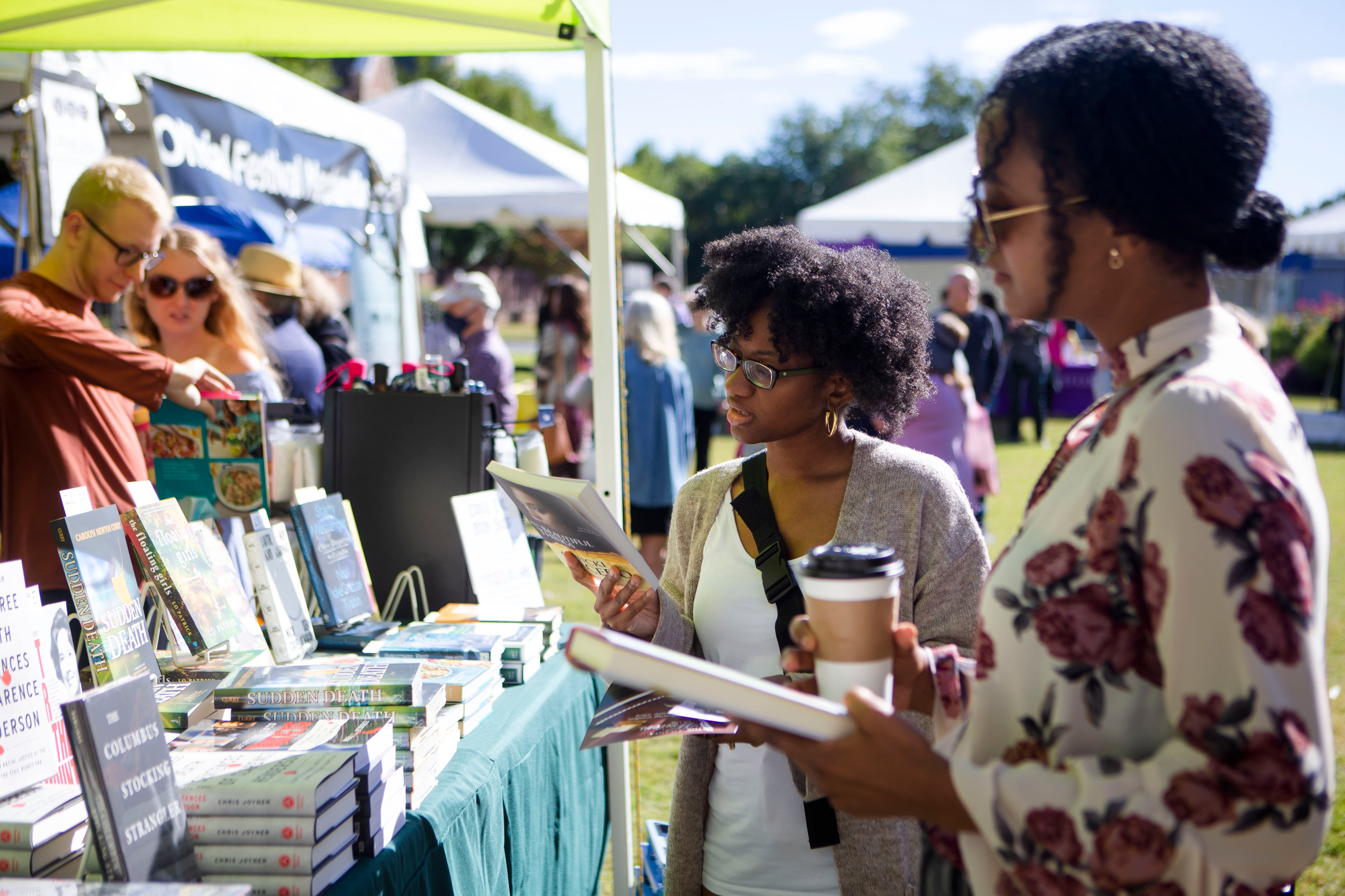 Candice Nicole (from left) and Shaliss Monet browse books during the Decatur Book Festival in 2022. (Christina Matacotta for the AJC)