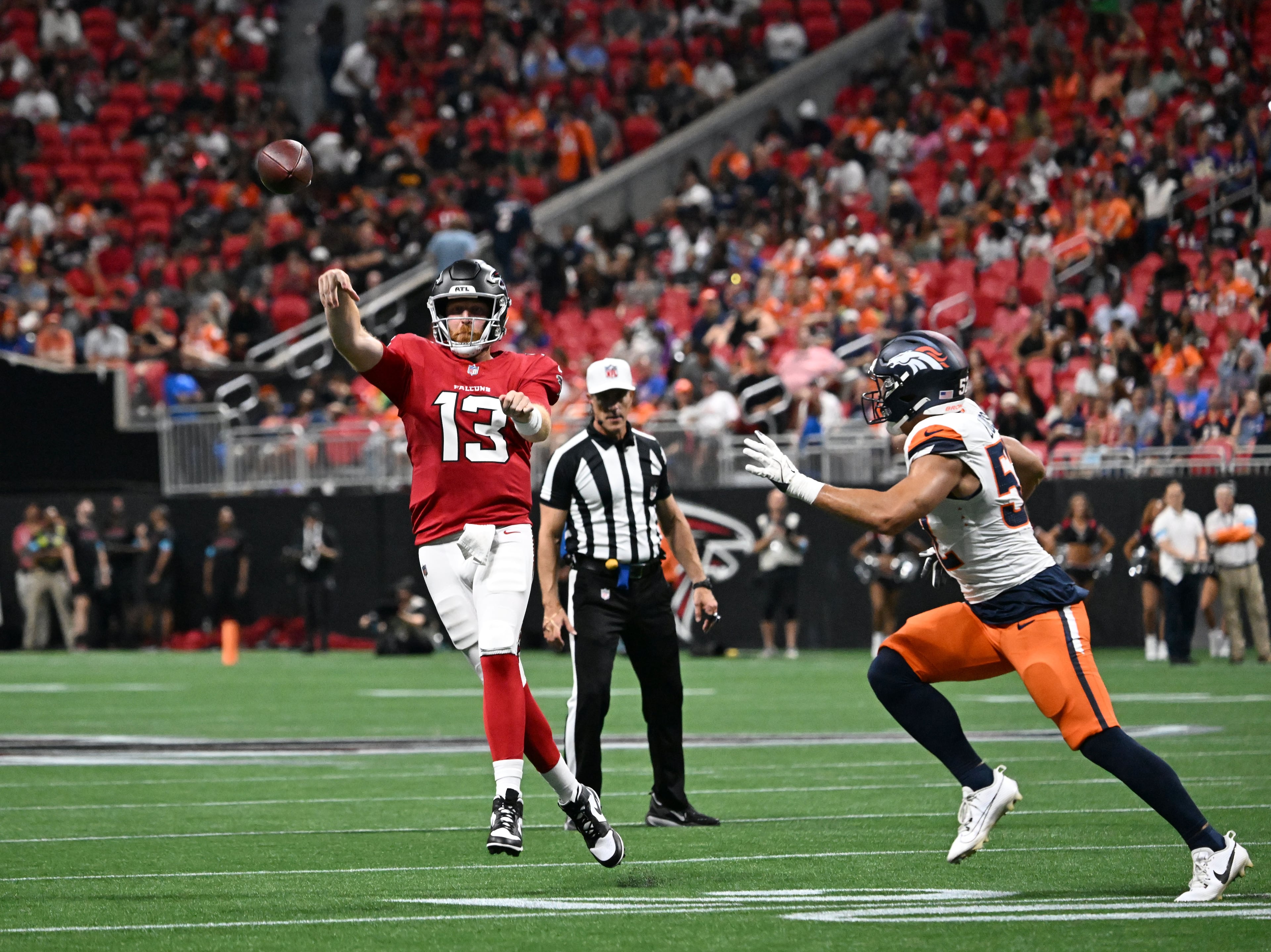 Falcons quarterback Cooper Rush (left) gets off a pass during their preseason game against the Denver Broncos at Mercedes-Benz Stadium on Friday, Aug. 14, 2026, in Atlanta. (Hyosub Shin/AJC)
