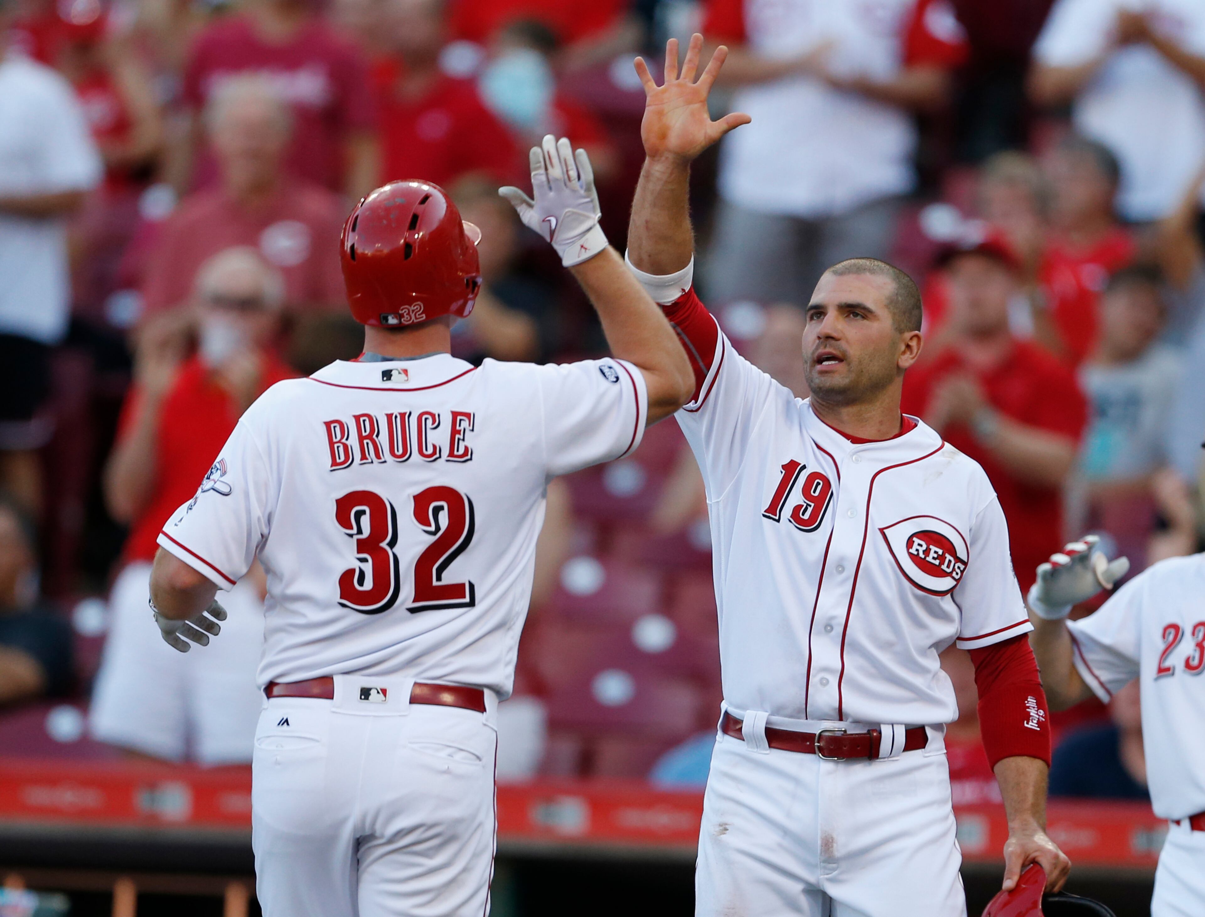 Cincinnati Reds' Jay Bruce (32) is congratulated by Joey Votto (19) after hitting a two-run homer off Atlanta Braves starting pitcher Tyrell Jenkins (61) during the first inning of a baseball game, Tuesday, July 19, 2016, in Cincinnati. (AP Photo/Gary Landers)