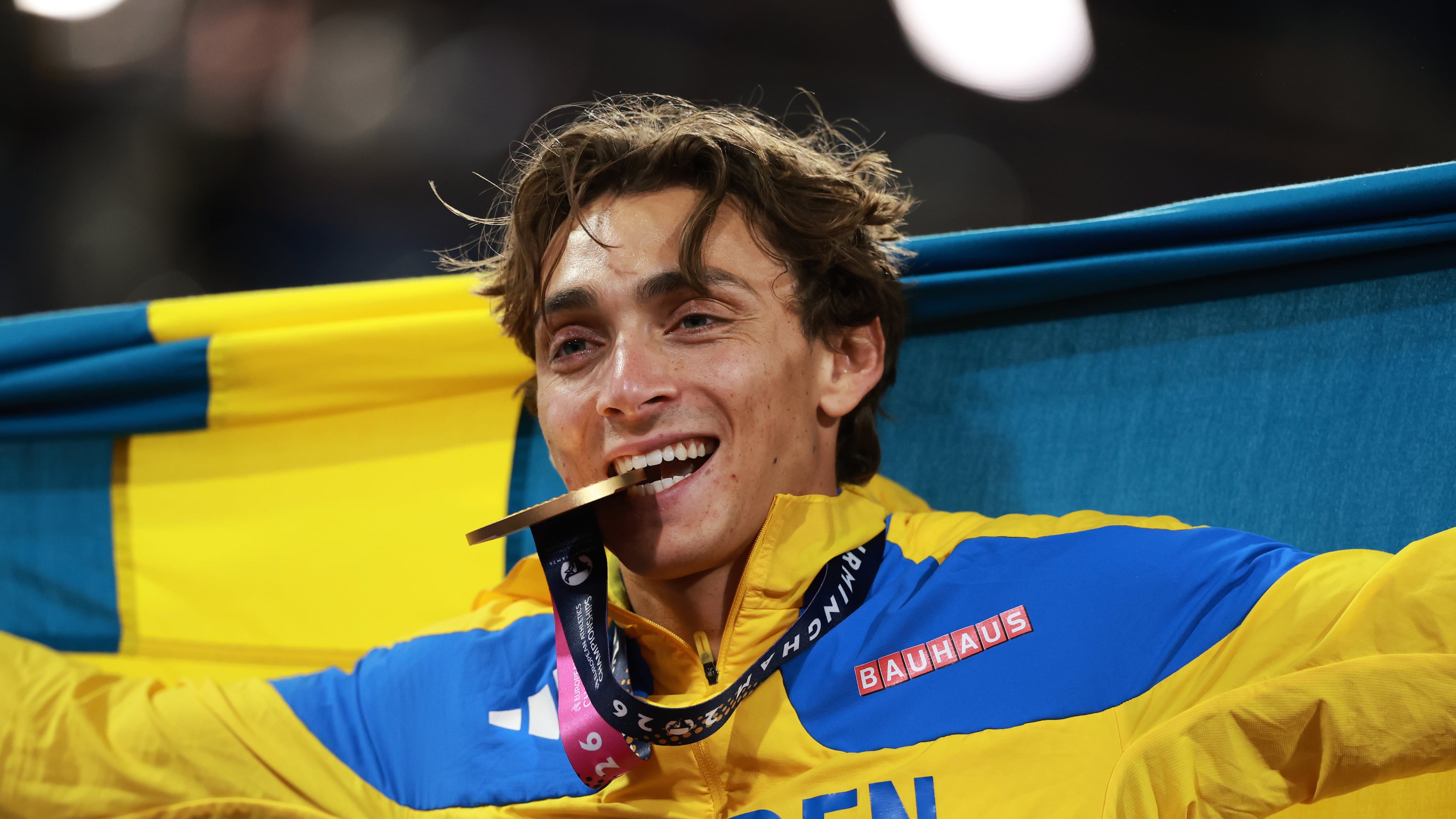Sweden's Armand Duplantis bites his gold medal as he celebrates winning the men's pole vault final at the European Athletics Championships in Birmingham, England, Sunday, Aug. 16, 2026. (AP Photo/Morgan Harlow)