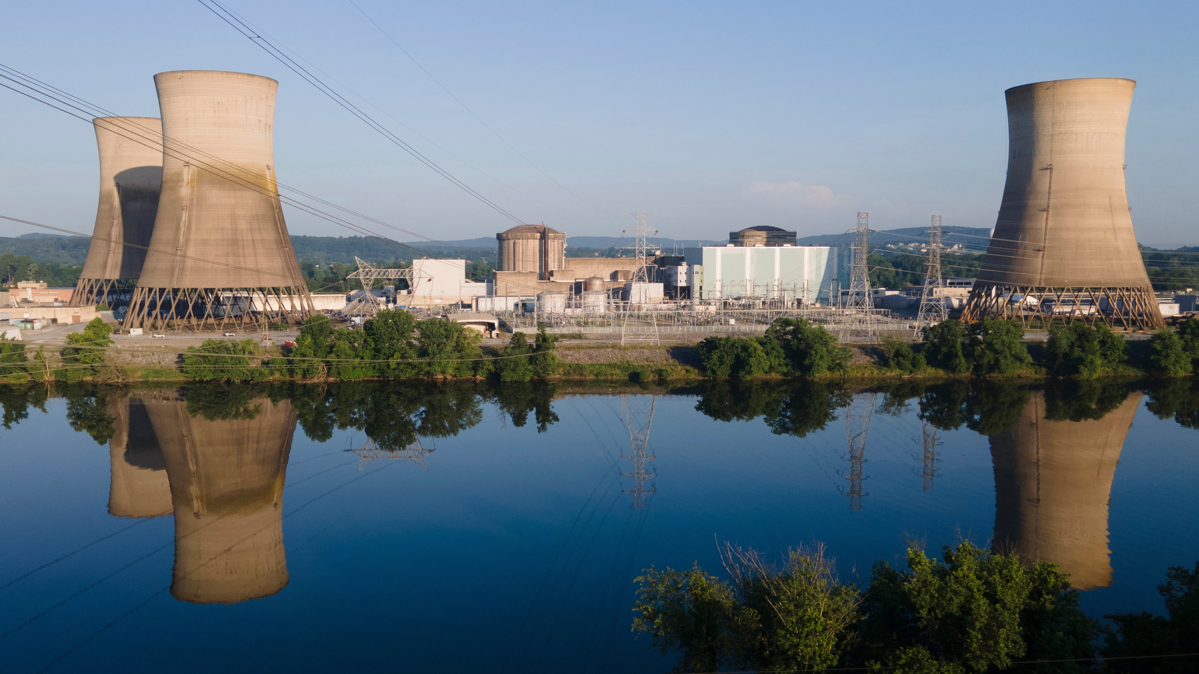 FILE - At Constellation's nuclear power plant on Three Mile Island, called the Crane Clean Energy Center, near Middletown, Pa., the cooling towers are reflected in the Susquehanna River, June 25, 2025. (AP Photo/Ted Shaffrey, File)