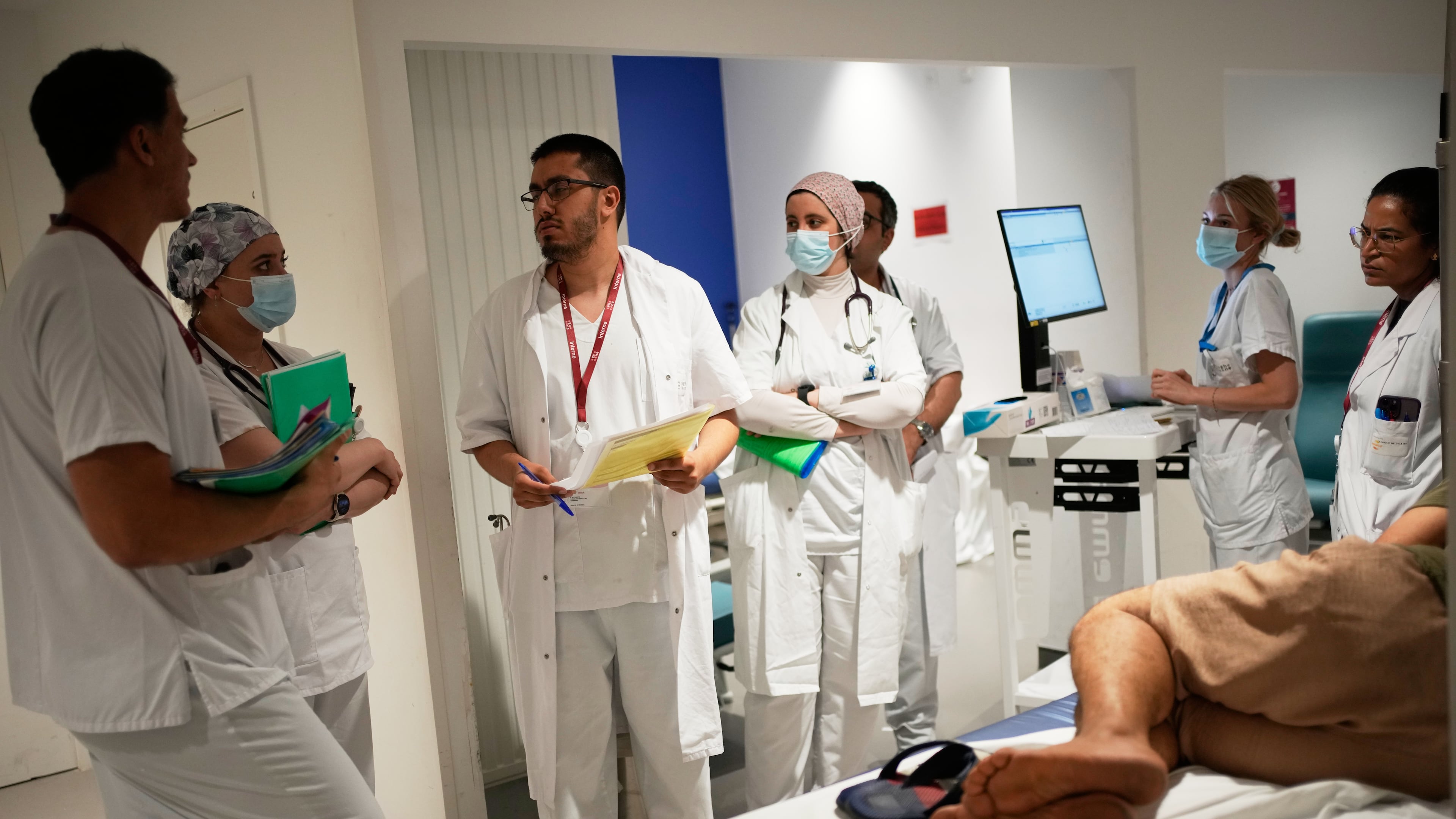 Doctors and nurses take care of a patient at the emergency department of the Paris-Saclay Hospital, outside Paris, Tuesday June 30, 2026. (AP Photo/Christophe Ena )