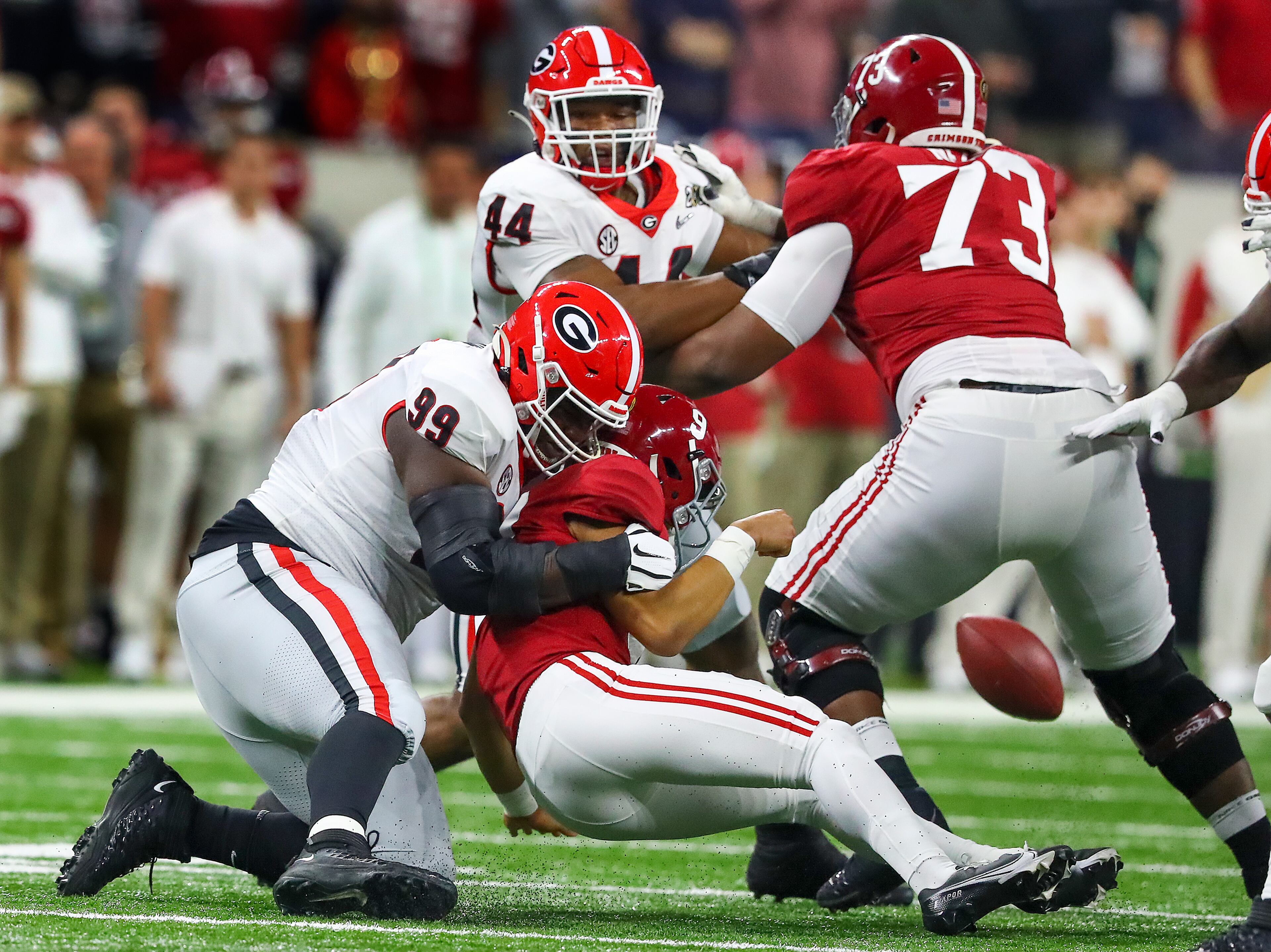 1/10/22 - Indianapolis -Georgia Bulldogs defensive lineman Jordan Davis (99) strips the ball from Alabama Crimson Tide quarterback Bryce Young (9) in the first quarter. Georgia recovered and appeared to score but it was ruled an incomplete pass at the 2022 College Football Playoff National Championship between the Georgia Bulldogs and the Alabama Crimson Tide at Lucas Oil Stadium in Indianapolis on Monday, January 10, 2022. Curtis Compton / Curtis.Compton@ajc.com