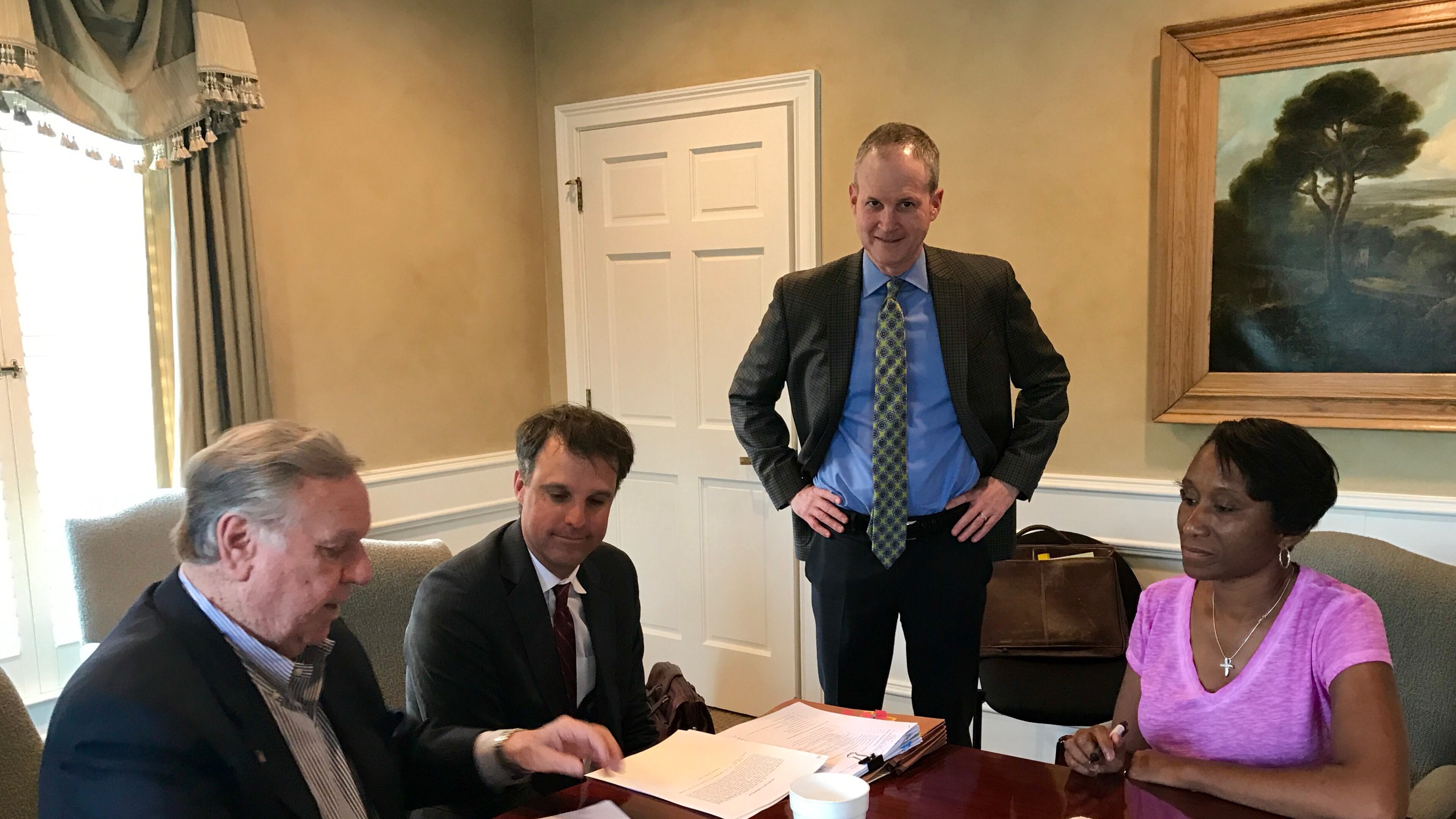 Powder Springs Development Authority Chair Murray Homan (far left) and Treasurer Krystal Wattley (right) sign the bond purchase resolution with Searles bond counsel David Williams and DAPS bond attorney Thomas Lauth (standing L-R). Courtesy of Powder Springs