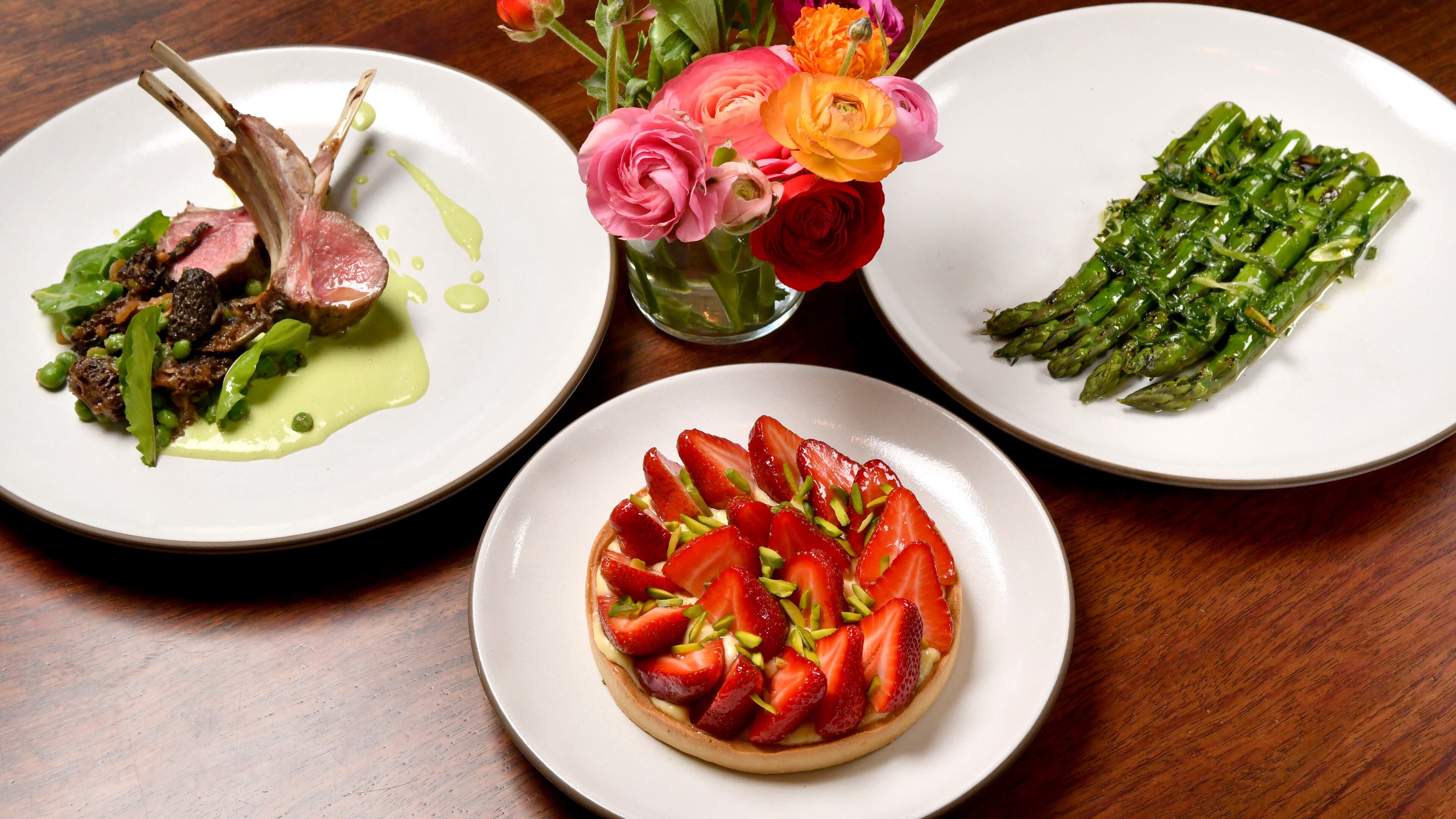 A spring menu from chef Forough Vakili of Le Bon Nosh in Buckhead includes (counterclockwise from right) Grilled Green Asparagus with Ramps Sauce, Georgia-Grown Grilled Lamb Rack with Pea and Morel Ragu, and Strawberry Tart. (Styling by chef Forough Vakili / Chris Hunt for the AJC)