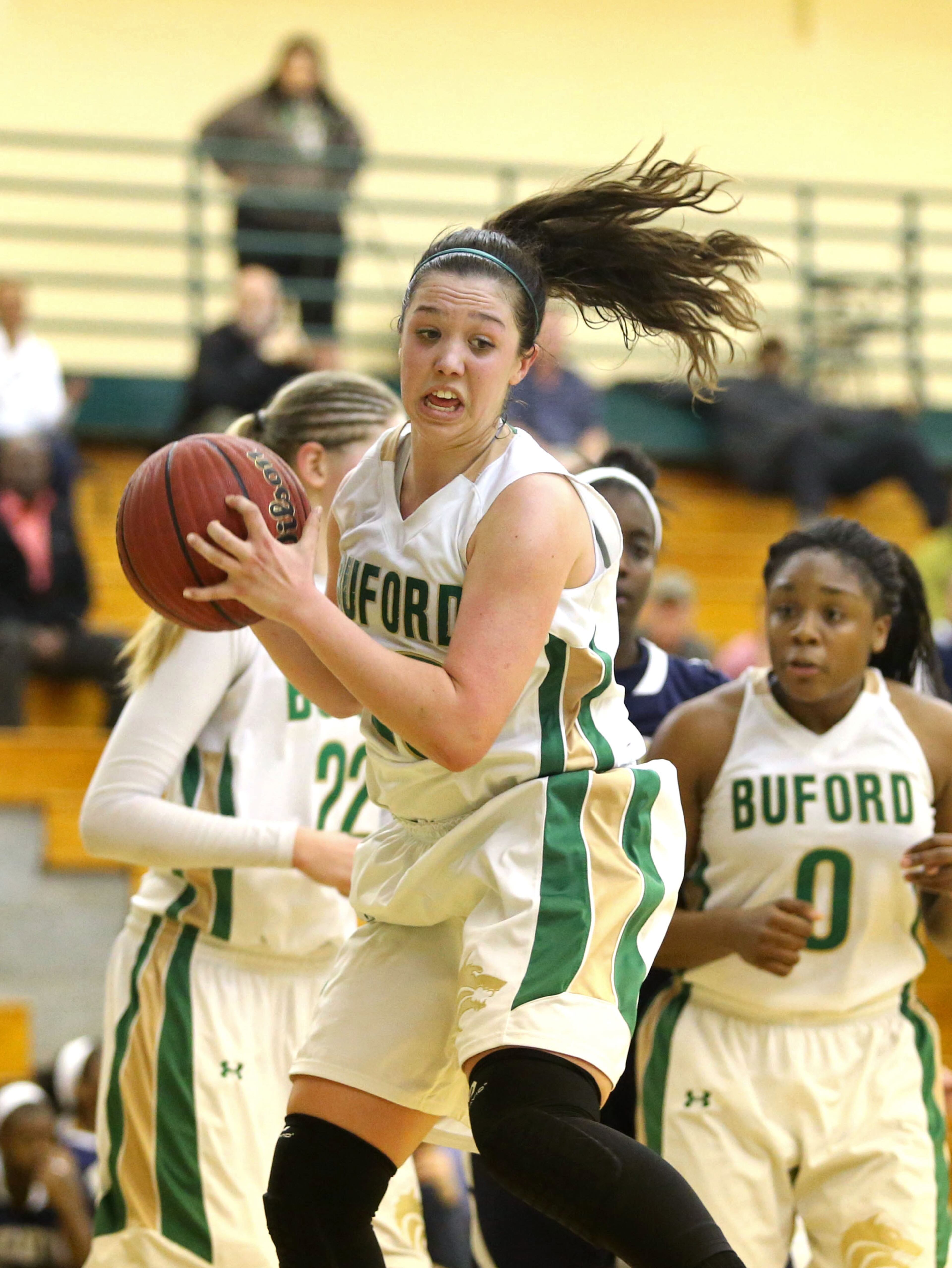 Buford's Chandler Hall, center, grabs a rebound during their game Monday night in Buford. Buford defeated Decatur 41-28 in the second round of the Class AAA state basketball tournament. JASON GETZ / SPECIAL