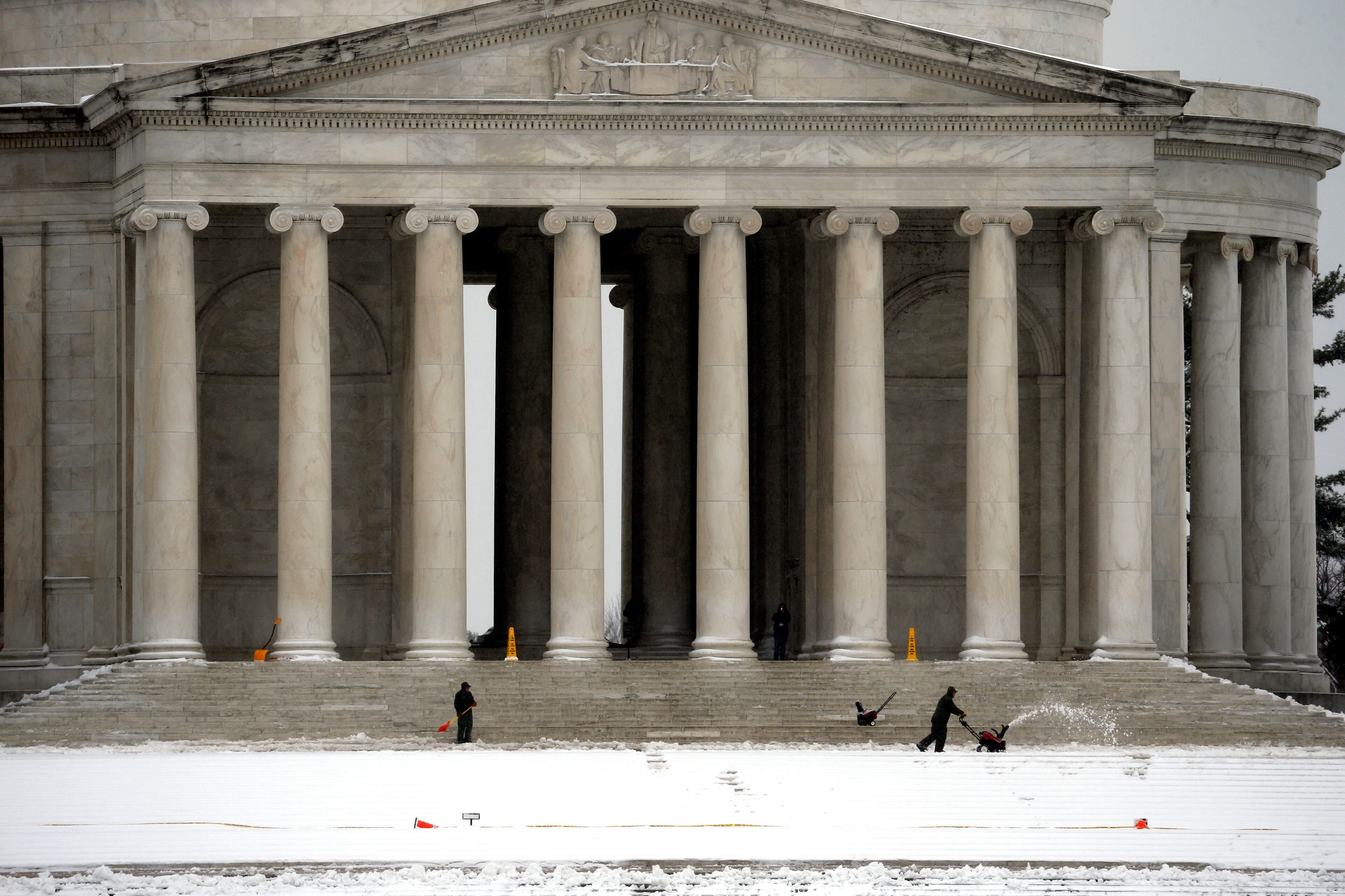 Workers a shovel and snow blower to clear the steps in front of the Jefferson Memorial after a winter snow storm on St. Patrick's Day, Monday, March 17, 2014 in Washington. The Cherry Blossom festival is scheduled to begin later this week. (AP Photo/Alex Brandon)