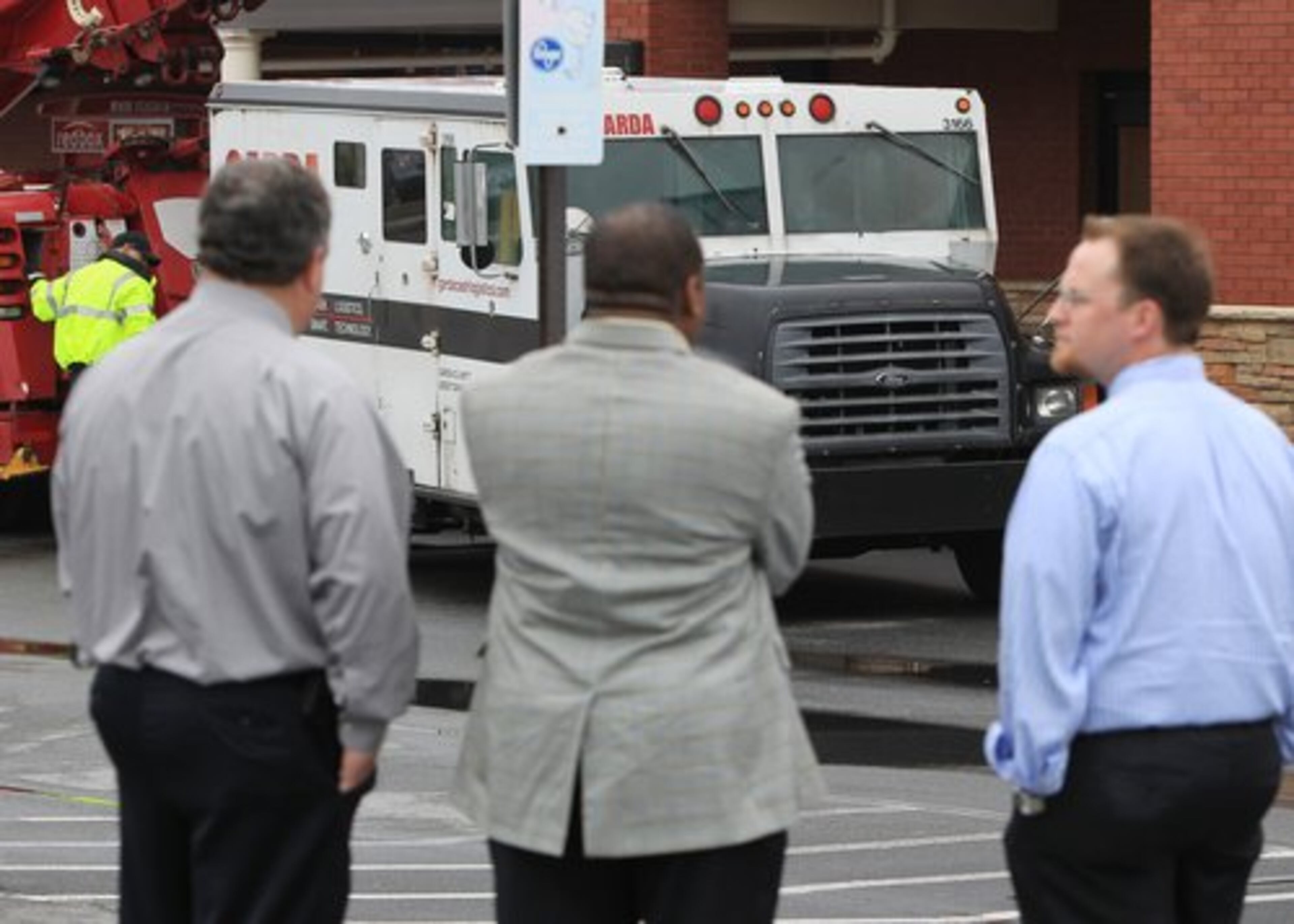 Bystanders look on a the scene. Officials said the act was captured on the Kroger surveillance video. "It really illustrates the ruthless nature of these armed robbers," FBI spokesman Stephen Emmett said, adding that the gunman "fired numerous times in an unprovoked fashion."