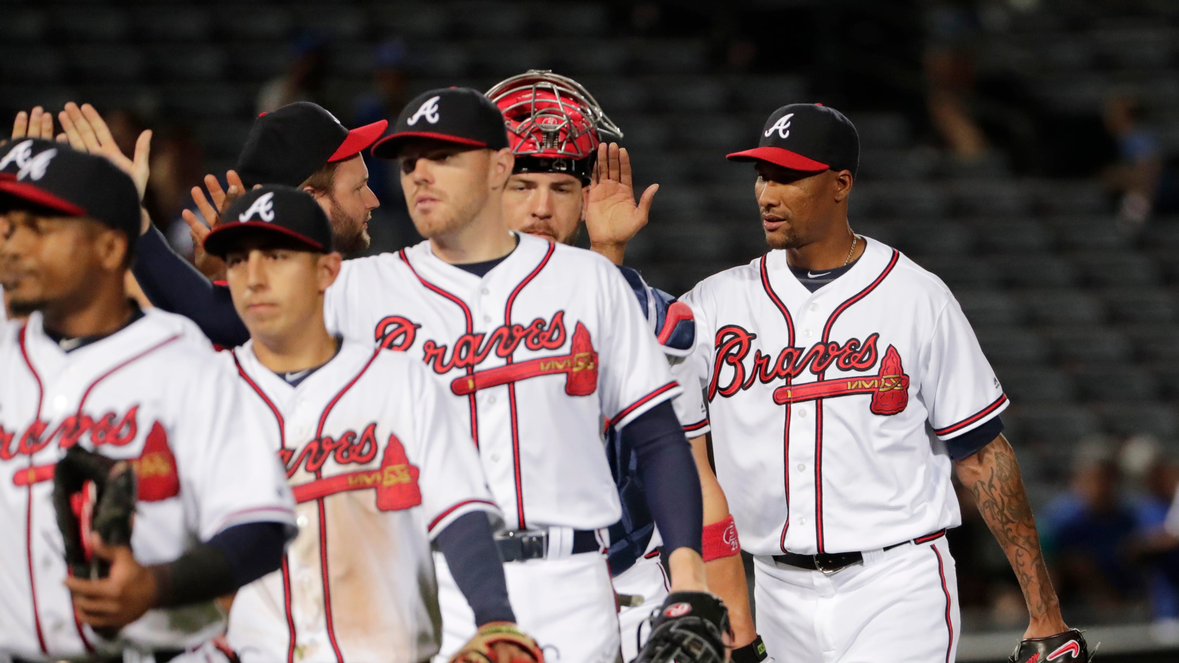 Atlanta Braves' relief pitcher Alexi Ogando, right, high-fives teammates after the Braves beat the Los Angeles Dodgers 8-1 in a baseball game Tuesday, April 19, 2016, in Atlanta. (AP Photo/David Goldman)