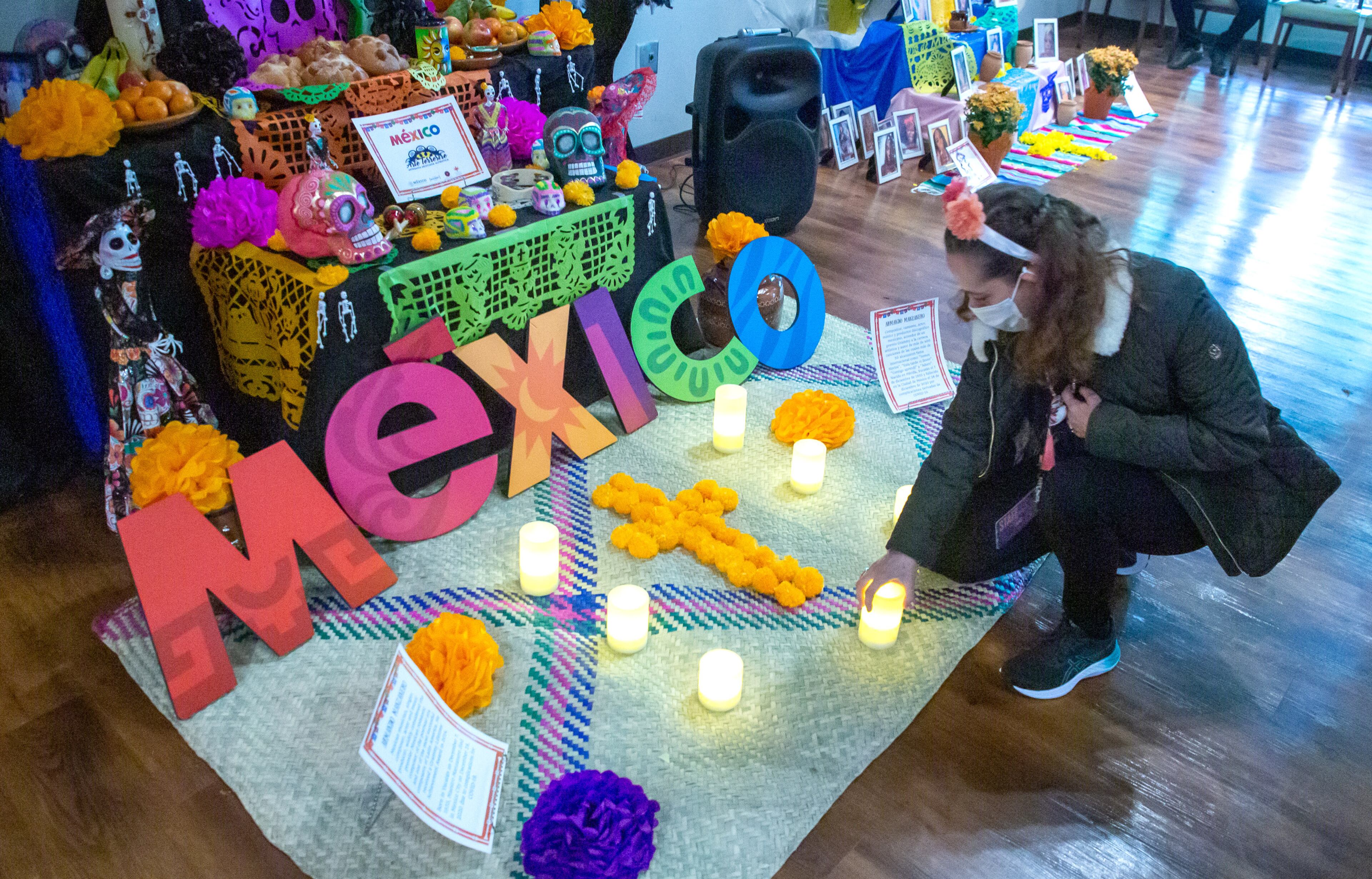 Claudia Rico puts the final touches on one of the altars during the Día de Muertos celebration at the Atlanta History Center Midtown on Sunday, October 31, 2021. (Photo: Steve Schaefer for The Atlanta Journal-Constitution)