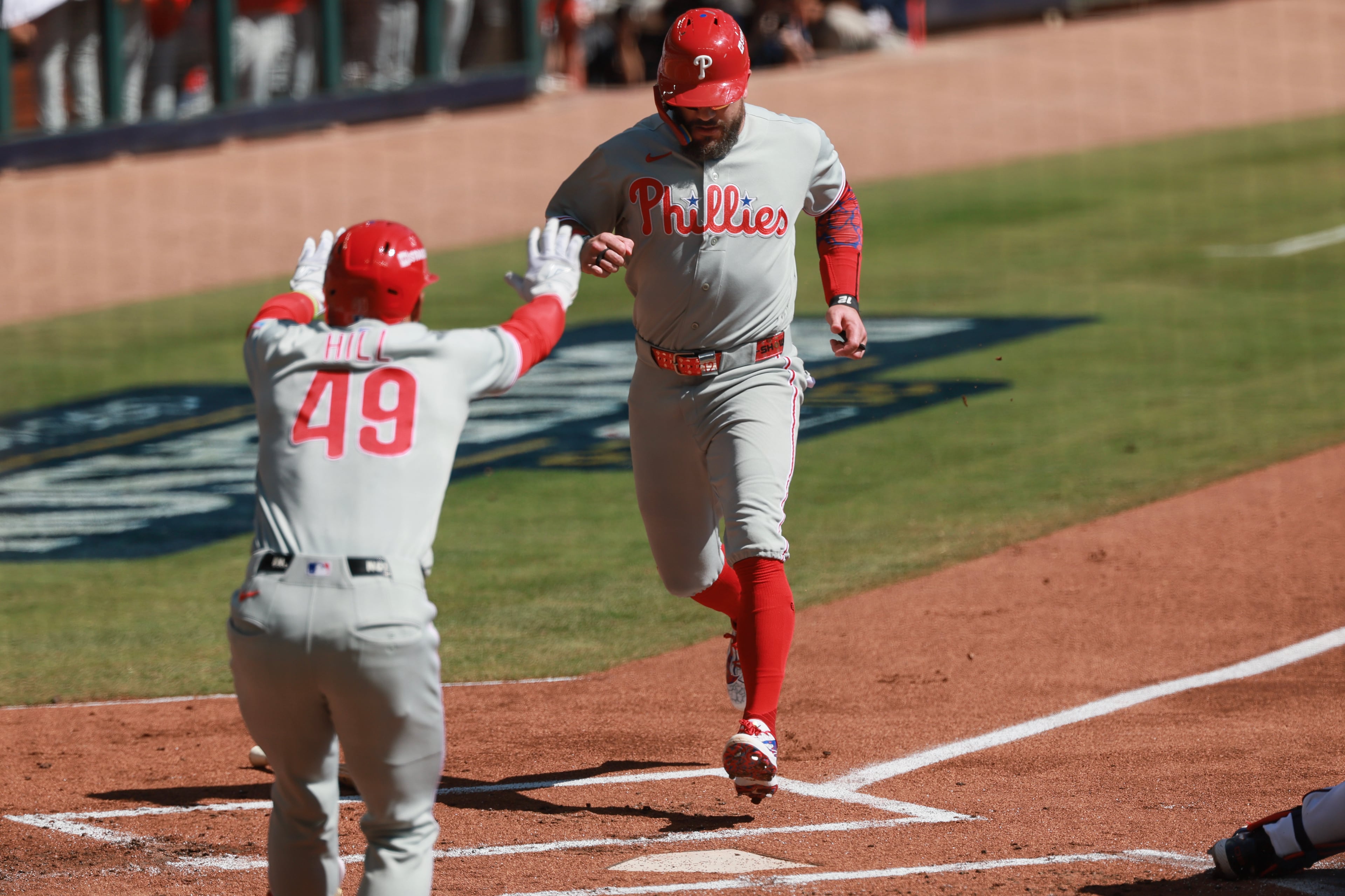 Philadelphia Phillies designated hitter Kyle Schwarber, right, scores against the Atlanta Braves during the first inning of Game 1 of a MLB National League Wild Card playoff series between the Atlanta Braves and the Philadelphia Phillies, Tuesday, Sept. 29, 2026, in Atlanta. (Jason Getz/AJC)