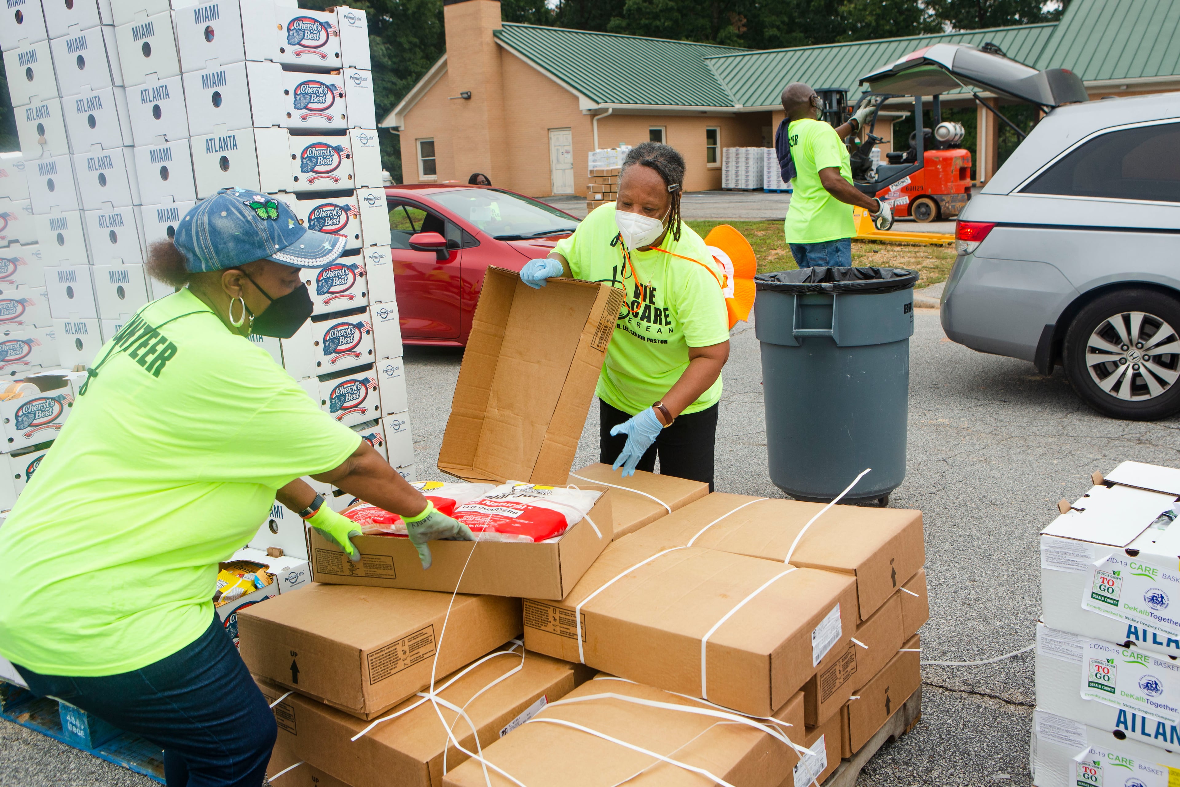 Valerie Henry (from left), Ora Goodwin and Robert Lindsey volunteer during a food giveaway event at Berean Christian Church on Saturday, August 27, 2022, in Stone Mountain. The free food was paid for using federal COVID-19 relief funds, and was distributed at churches throughout DeKalb County. CHRISTINA MATACOTTA FOR THE ATLANTA JOURNAL-CONSTITUTION.