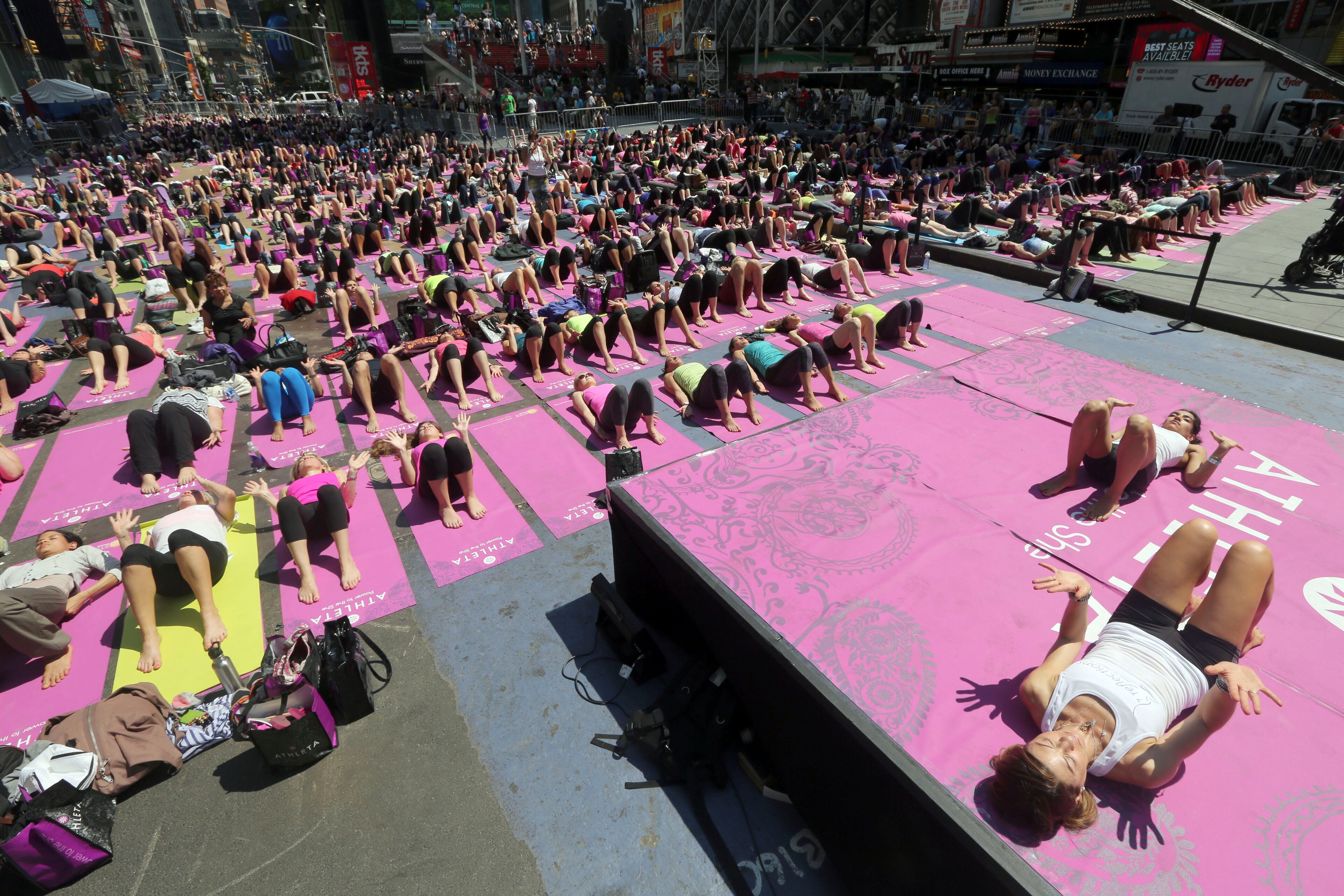 People practice yoga in New York's Times Square, Friday, June 21, 2013. Yoga enthusiast marked the longest day of the year with five free "Mind Over Madness" yoga classes during the11th annual Solstice in Times Square. (AP Photo/Mary Altaffer)
