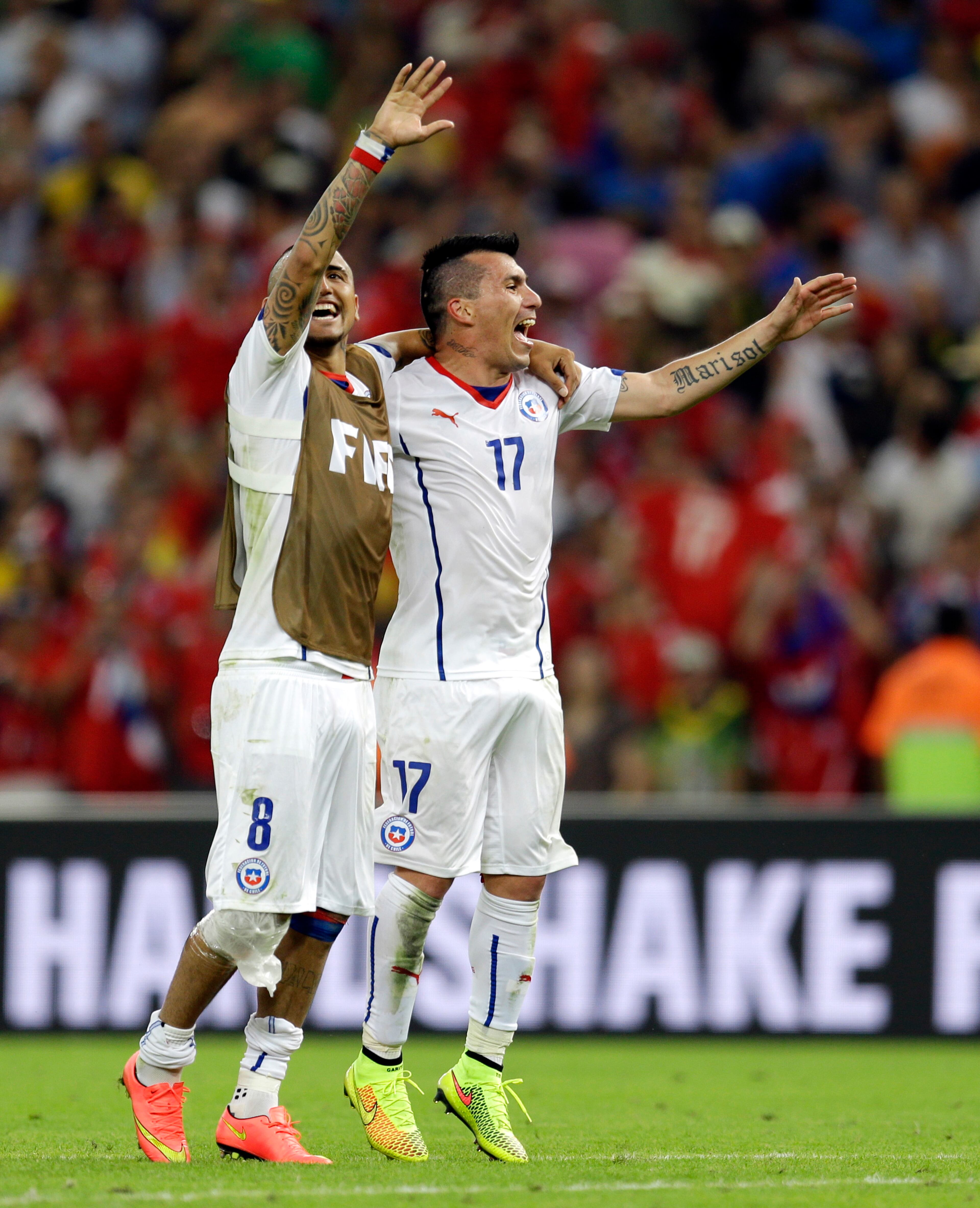 Chile's Arturo Vidal, left, and Chile's Gary Medel celebrate after their victory in the group B World Cup soccer match between Spain and Chile at the Maracana Stadium in Rio de Janeiro, Brazil, Wednesday, June 18, 2014. Defending champion Spain was eliminated from the World Cup after losing to Chile 2-0. (AP Photo/Natacha Pisarenko)