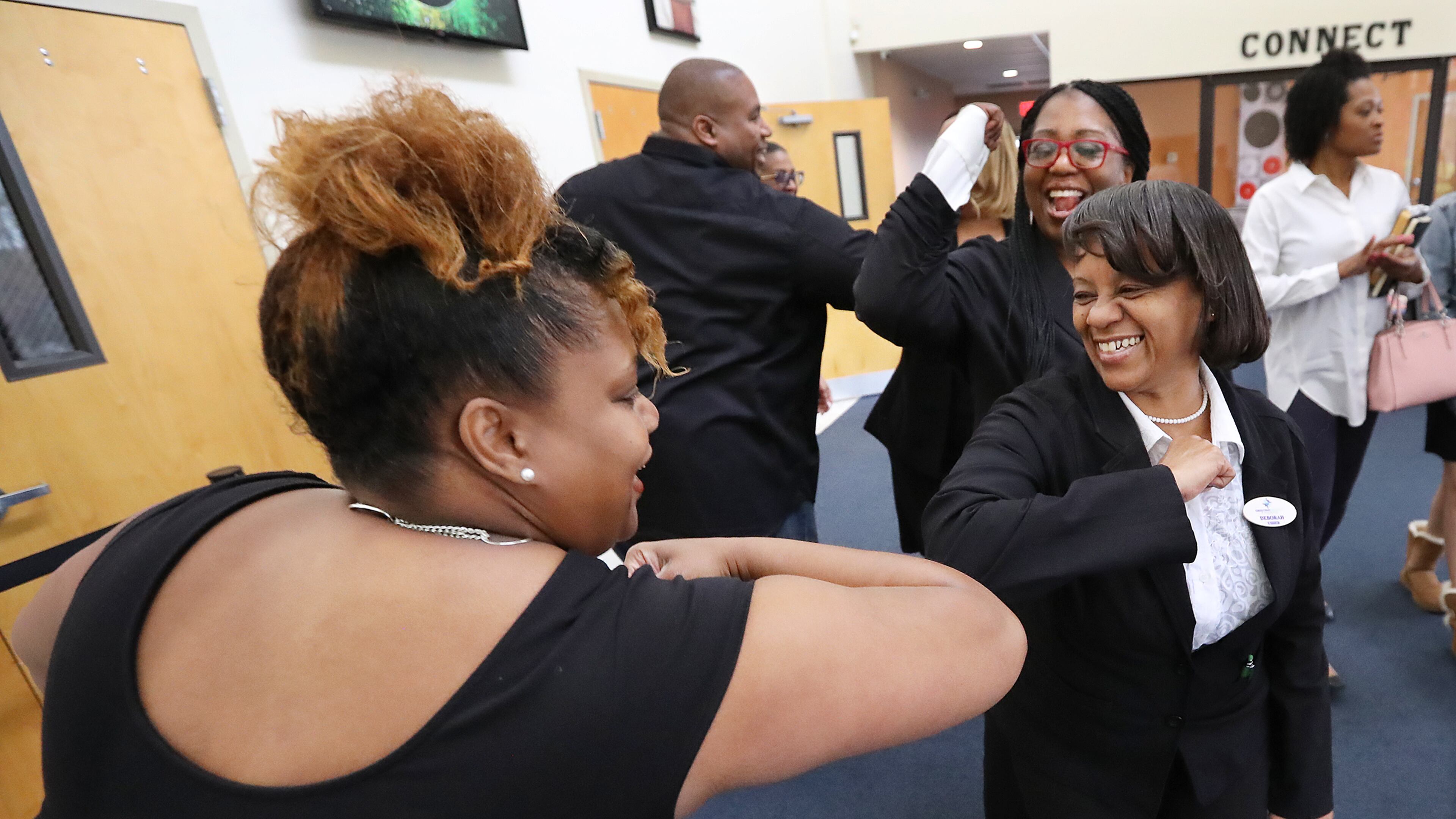 Bernadette Walker (left) and Deborah Johnson, along with other members, bump elbows as they arrive for worship service at Destiny World Church in Austell last year in the early days of the pandemic. The church will have free COVID-19 vaccine events for the community this Saturday and on Oct. 9. (Curtis Compton / ccompton@ajc.com)