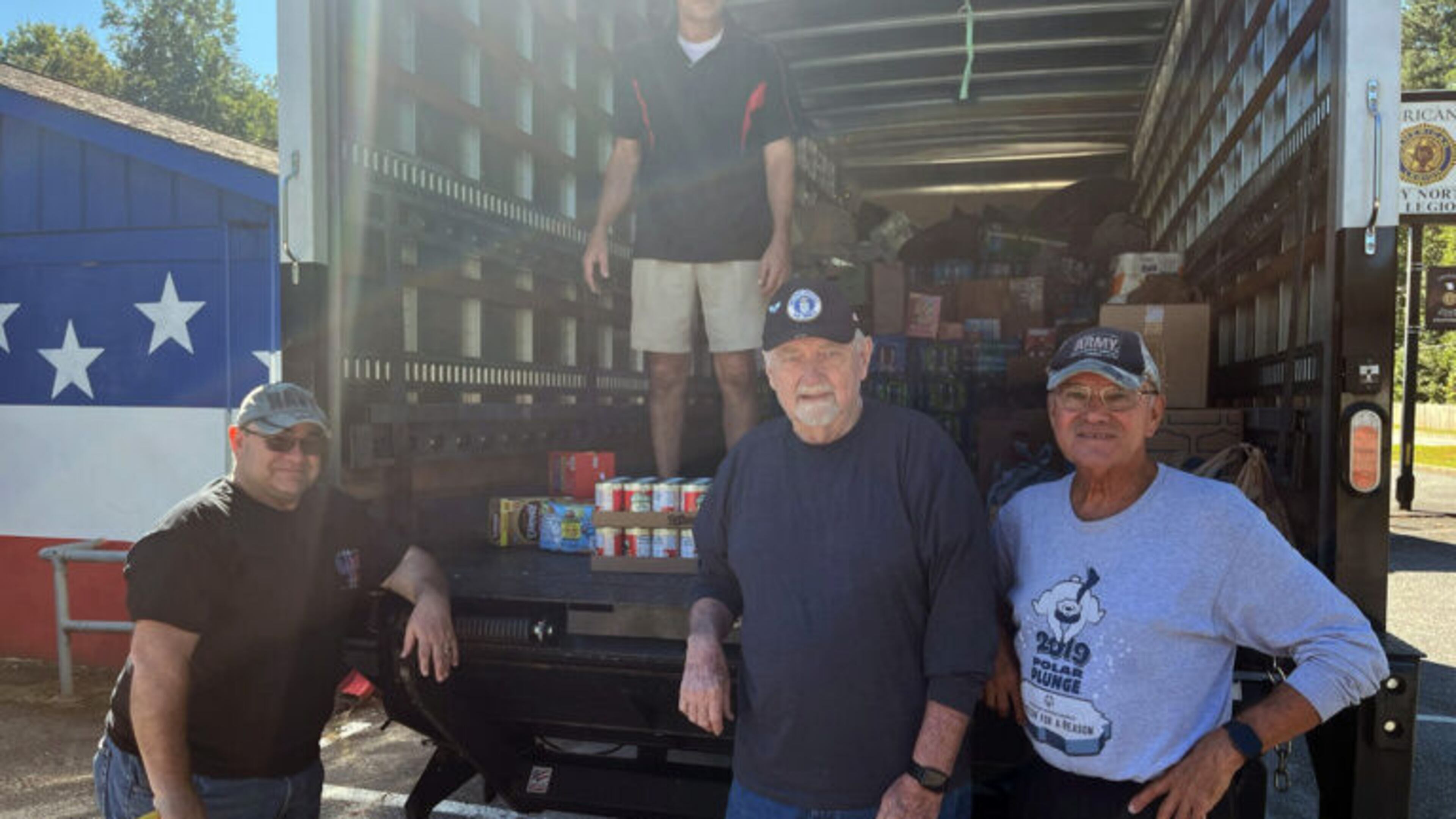 From left, Dan Harr; Jess, on the truck; Howard Kanour; and Ron Asby American Post 304 Commander Chuck Guta loading the truck.