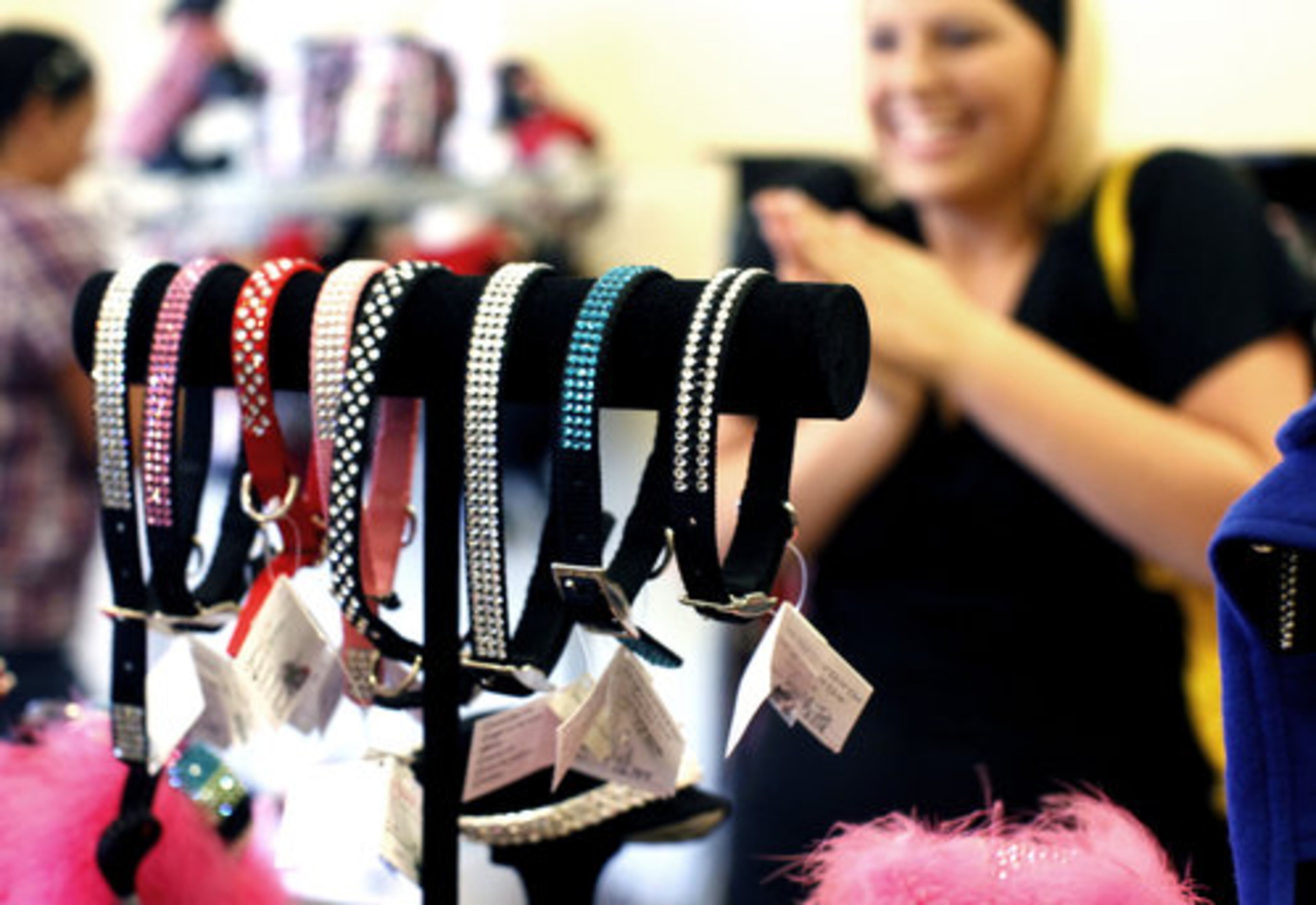 Customers browse a display of Swarovski crystal dog collars at the Beverly Hills Mutt Club in Beverly Hills, Calif. The shop is small but bursting with things made of Swarovski crystal, pearls, cashmere, wool, Italian leather and other soft and shiny things.