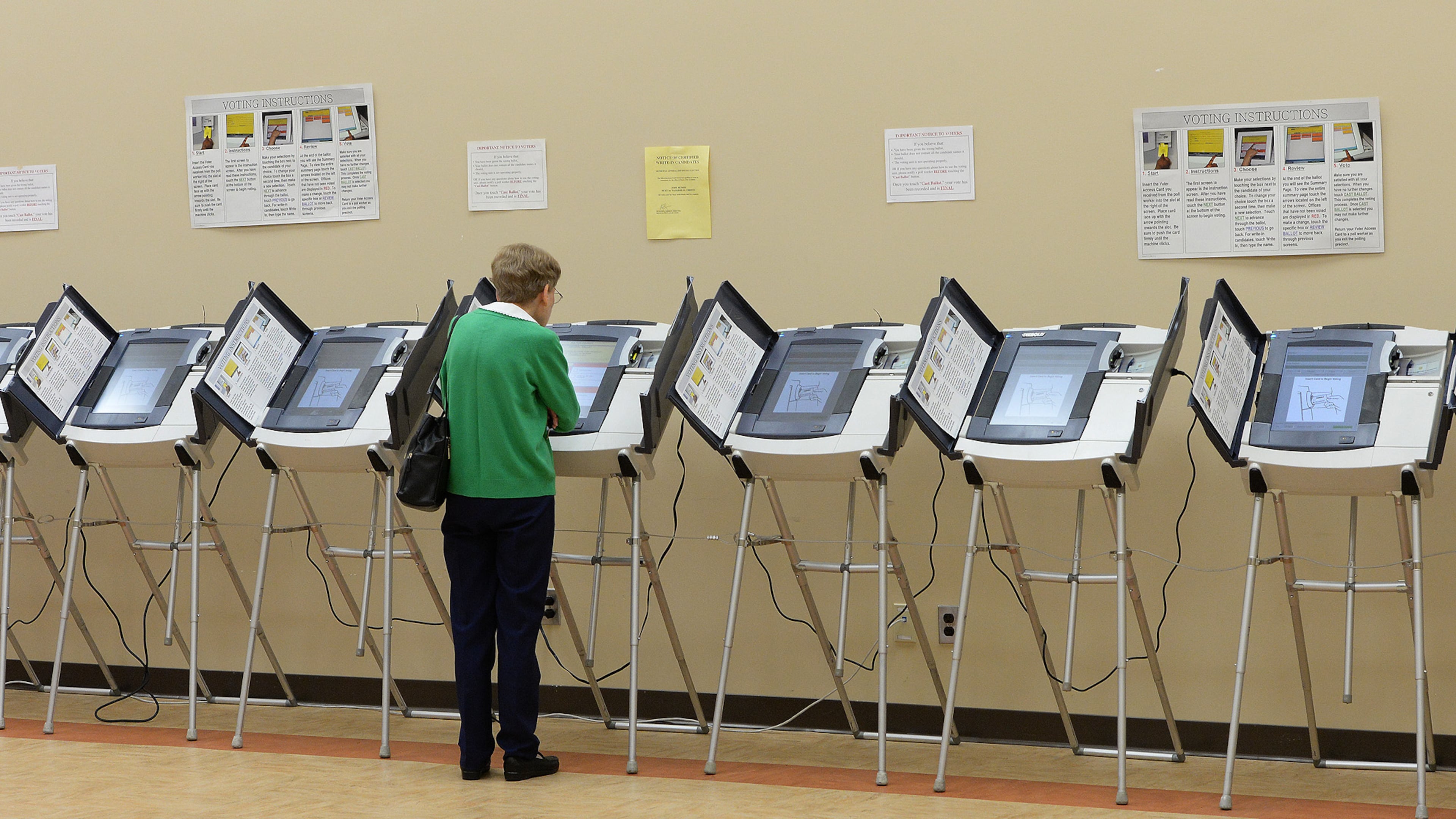 In this 2013 AJC file photo, a voter uses a balloting machine at the North Fulton Service.