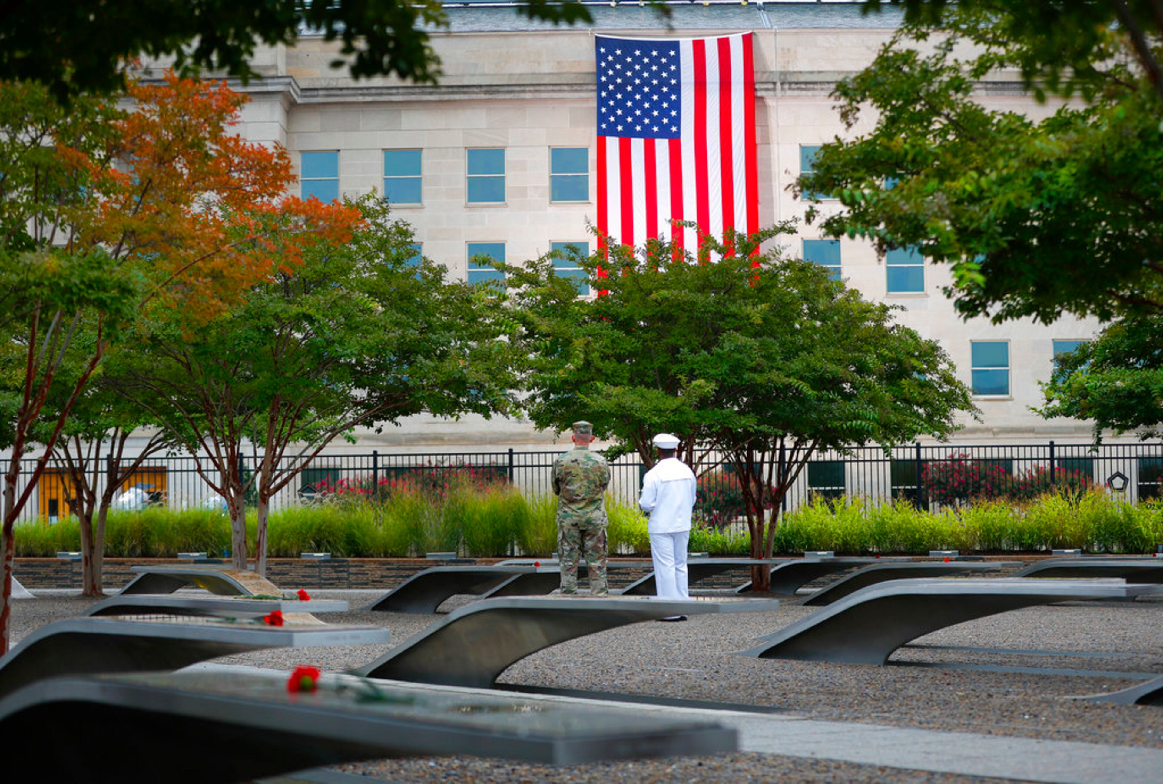 Members of the military are seen on the grounds of the National 9/11 Pentagon Memorial before the start of the September 11th Pentagon Memorial Observance at the Pentagon on the 17th anniversary of the September 11th attacks, Tuesday, Sept. 11, 2018. (AP Photo/Pablo Martinez Monsivais)