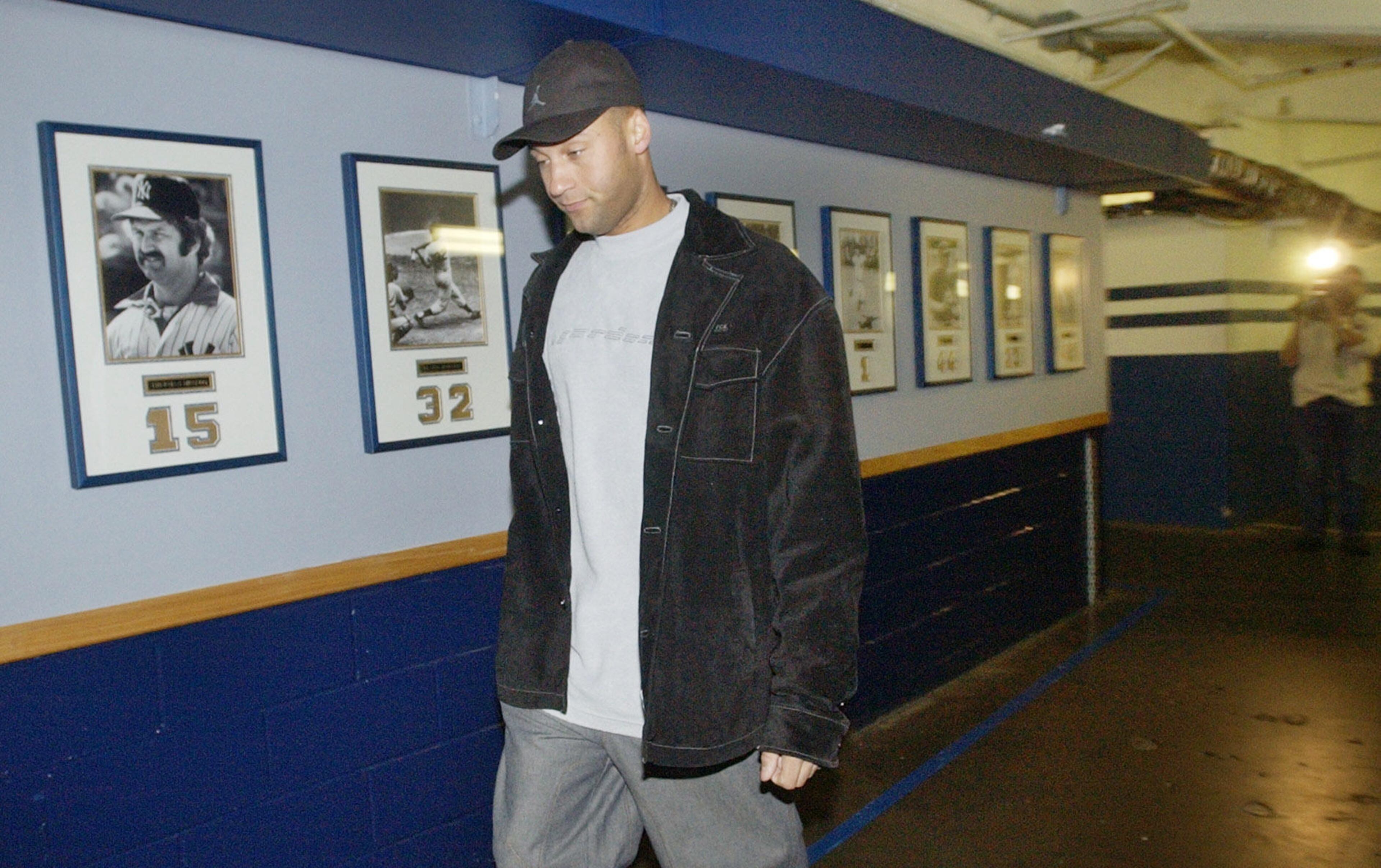 FILE - In this Oct. 27, 2003, file photo, New York Yankees shortstop Derek Jeter walks past a wall of photographs of former Yankees players en route to the team clubhouse at Yankee Stadium in New York. Jeter is set to retire after this weekend. A five-time World Series champion and sixth on the career hits list, he spent two decades as the shortstop for the New York Yankees. (AP Photo/Kathy Willens, File)