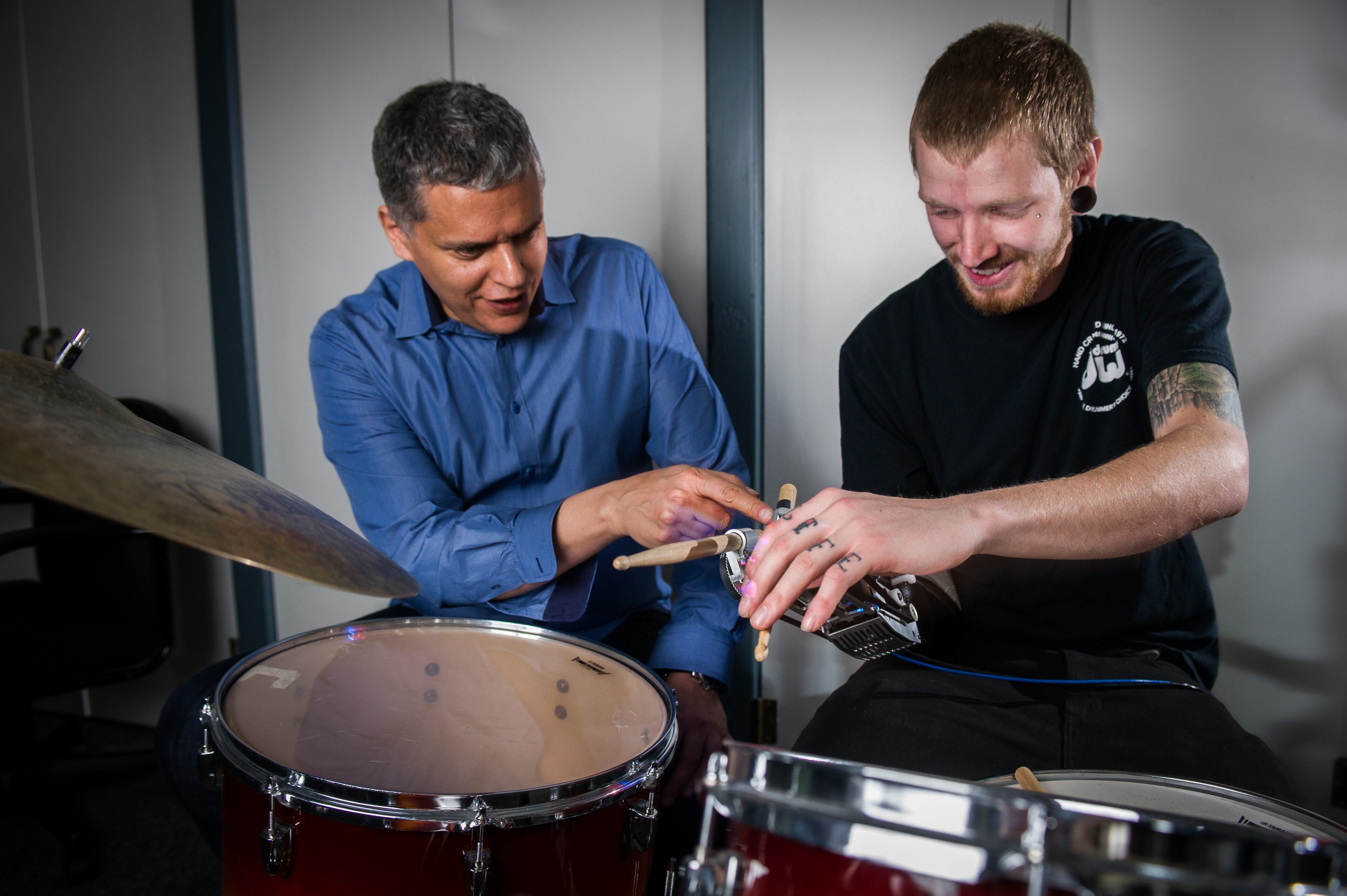 Jason meets with Georgia Tech professor Gil Weinberg, founding director of the Georgia Tech Center for Music Technology, as he tries on his robot arm.