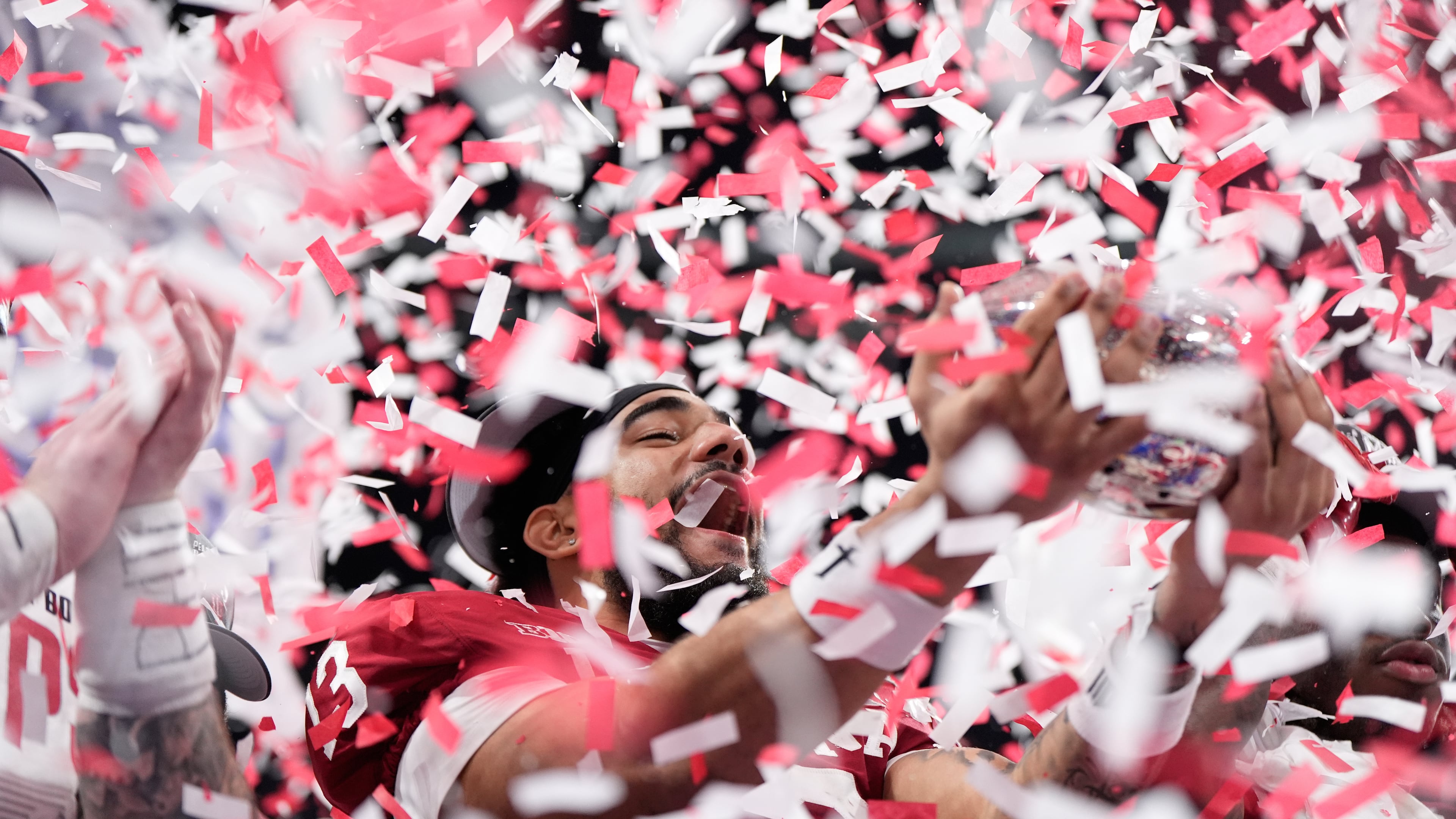 Indiana wide receiver Elijah Sarratt (13) holds up the trophy after the Peach Bowl NCAA college football playoff semifinal against Oregon, Friday, Jan. 9, 2026, in Atlanta. (AP Photo/Brynn Anderson)