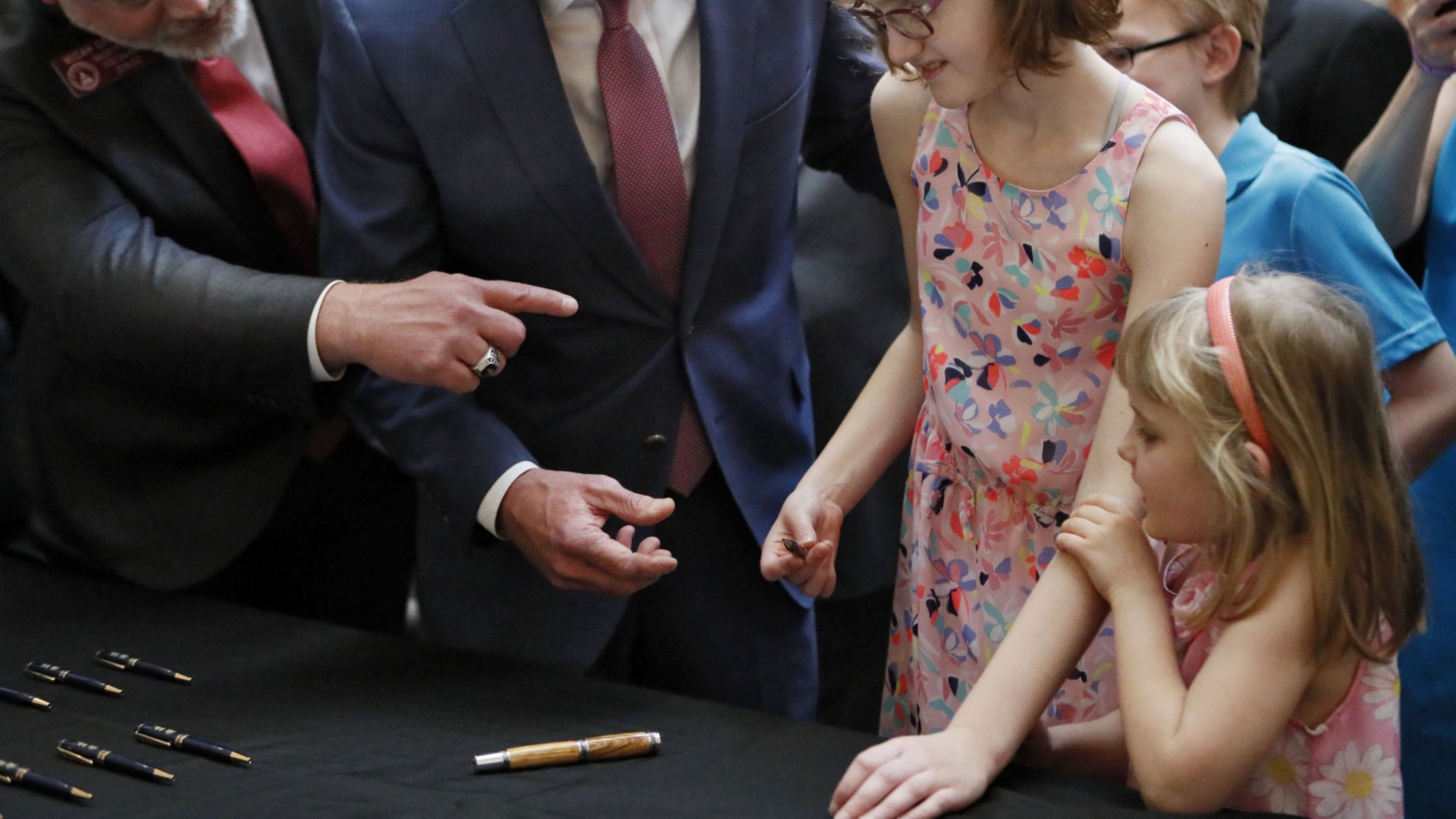 After the signing a bill to allow the in-state cultivation and manufacture of a marijuana oil for medical purposes, Gov. Brian Kemp, with the bill’s author, state Rep. Micah Gravley, R-Douglasville, gave a ceremonial pen to 13-year-old Alaina Cloud. Alaina, who has a severe form of epilepsy that causes uncontrollable seizures, was joined by her sister, Courtney, 5. Kemp, joined by medical marijuana users and advocates, signed HB 324, which will also allow medical marijuana oil to be sold in Georgia for the first time. Bob Andres / bandres@ajc.com