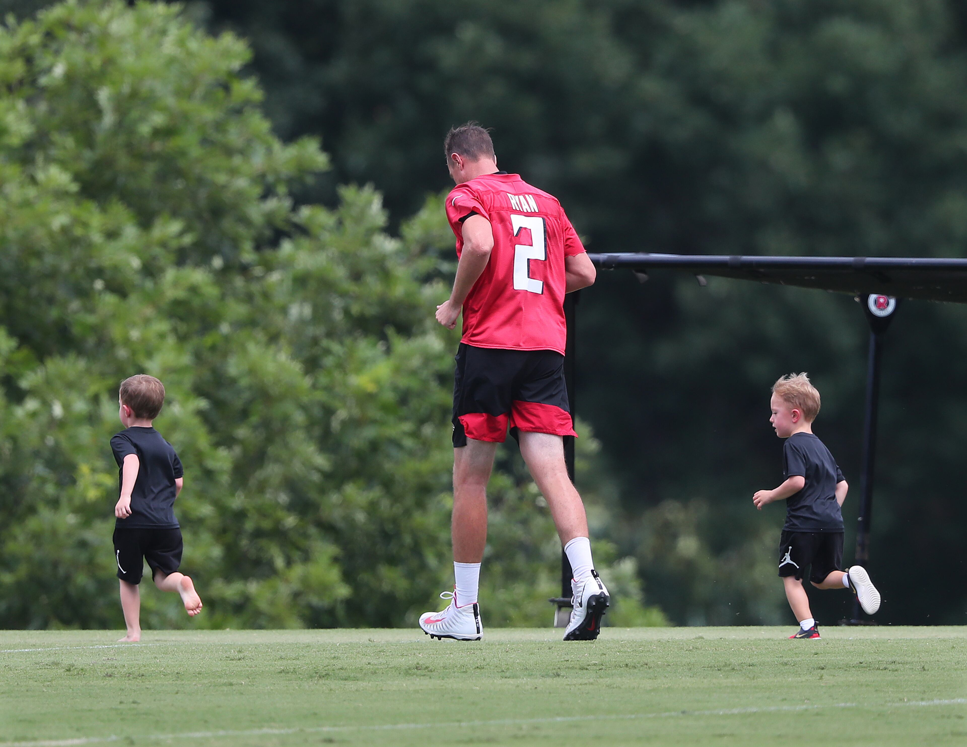 Falcons quarterback Matt Ryan gets in some laps around the practice field with his sons Marshall and Johnny after the fourth day of training camp practice Sunday, Aug. 1, 2021, in Flowery Branch. (Curtis Compton / Curtis.Compton@ajc.com)