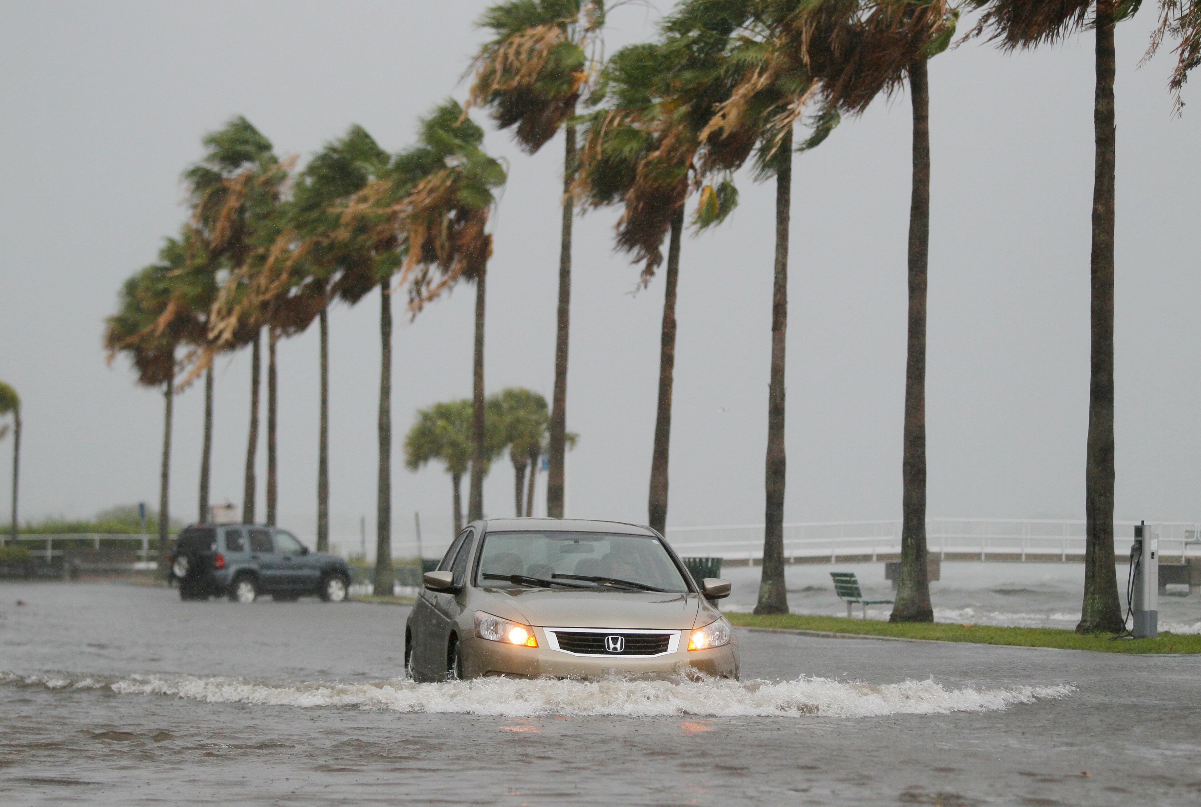 A vehicle moves through water from Tropical Storm Colin in Gulfport, Fla., Monday, June 6, 2016. A large portion of Florida's western and Panhandle coast was already under a tropical storm warning when the National Hurricane Center announced that a swift-moving depression had become a named storm. (Dirk Shadd/The Tampa Bay Times via AP)