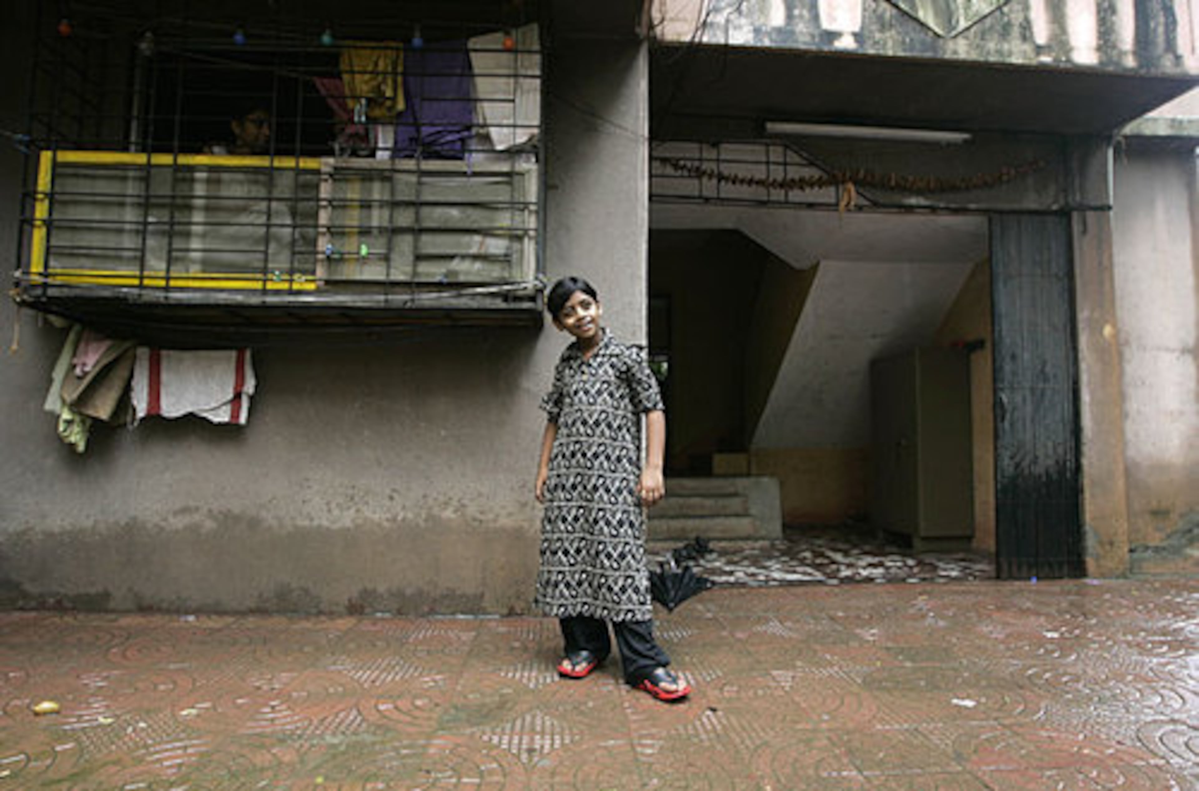 Azharuddin Mohammed Ismail, one of the child stars of the Oscar-winning movie "Slumdog Millionaire," poses outside his new house in a residential complex in suburban Mumbai, India. The makers of the hit movie bought the new home for Azhar after authorities demolished parts of the slum area where he and his family had lived.