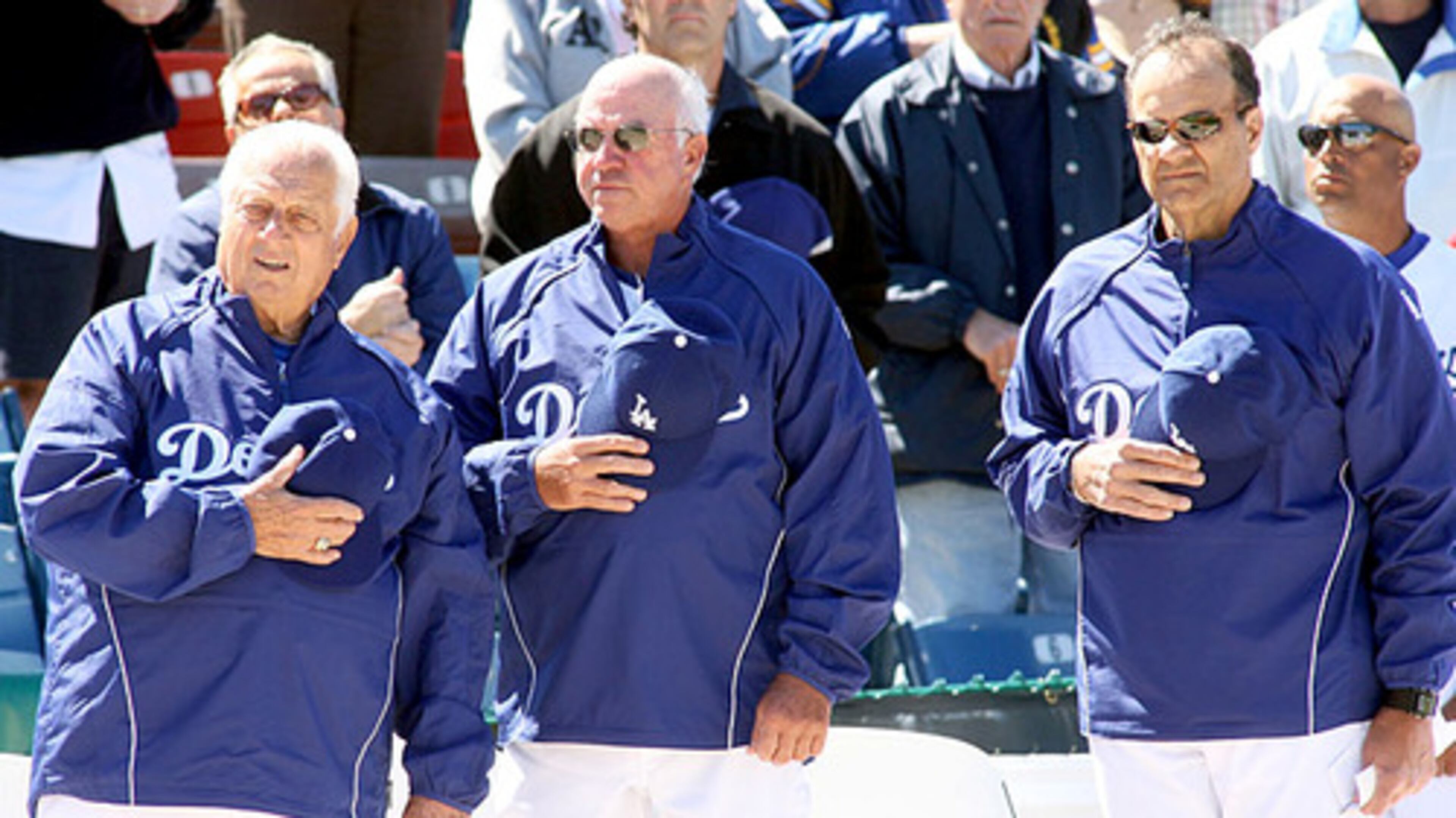 The Dodgers' Tommy Lasorda, bench coach Bob Schaefer and new manager Joe Torre pay respects during the national anthem.