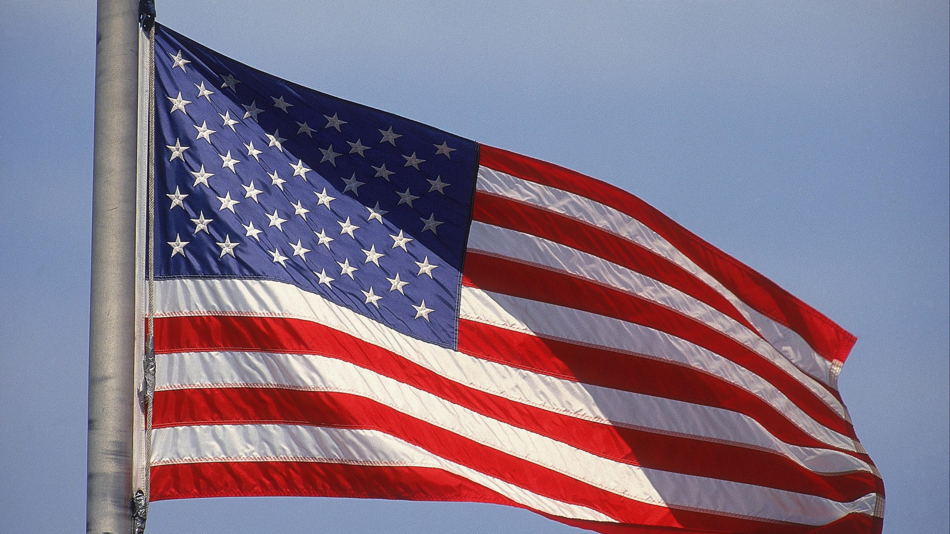A man carrying an American flag and a pistol near the site of the mass shooting at Santa Fe High School in Texas sparked anger Friday.