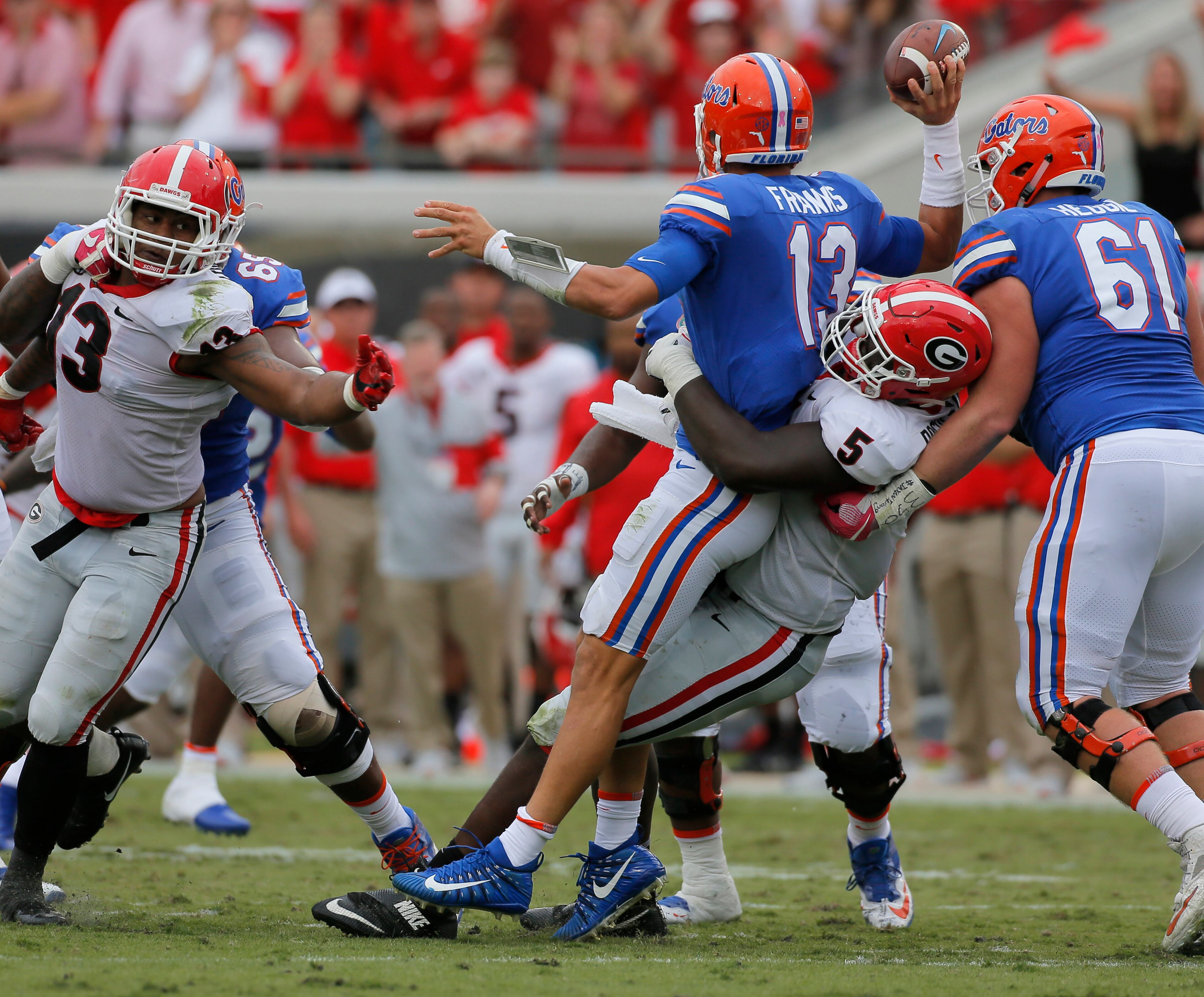 10/28/17 - Jacksonville, FL - Georgia Bulldogs defensive lineman Julian Rochester (5) has Florida Gators quarterback Feleipe Franks (13) in his grasp as Franks dumps the ball off incomplete. NCAA football game between Georgia and Florida at EverBank Field in Jacksonville. BOB ANDRES /BANDRES@AJC.COM