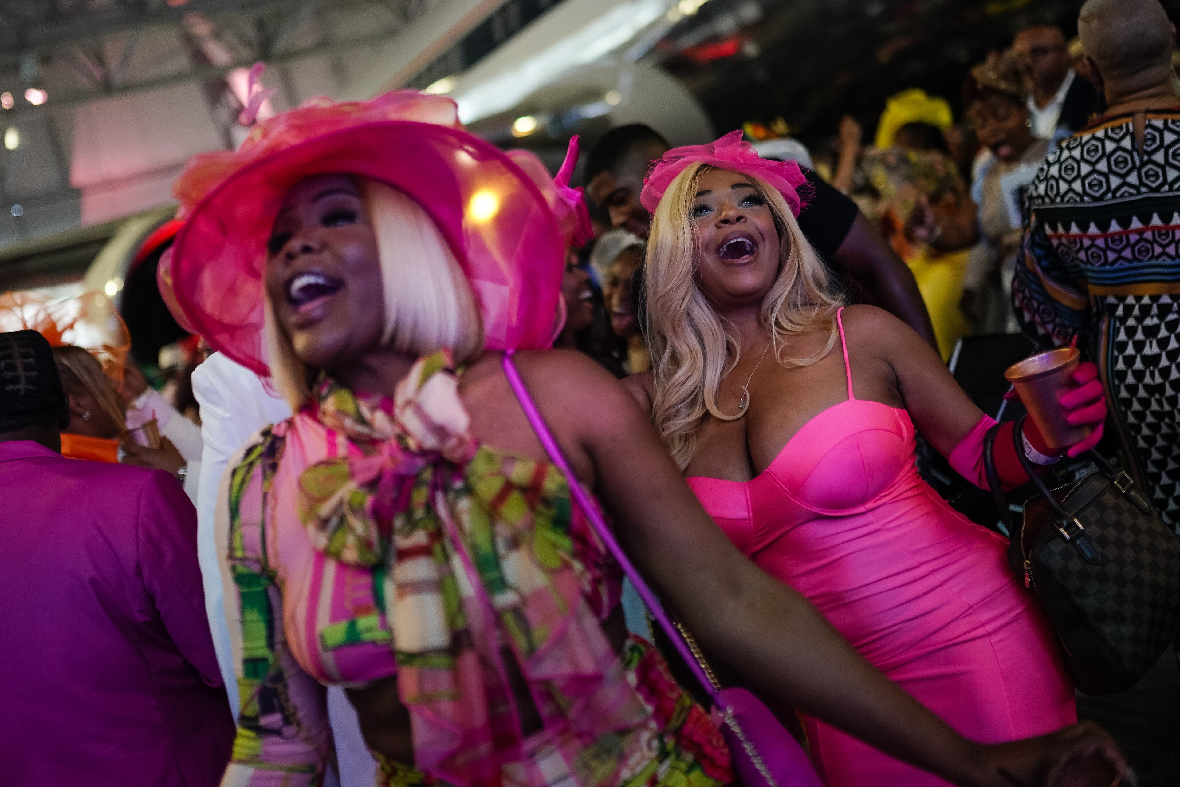 Merlande Petithomme, left, and Crystal Woodford, right, dance at the Alpha Derby Kentucky Derby watch party at the Delta Flight Museum on Saturday, May 4, 2024, in Atlanta. (Elijah Nouvelage for The Atlanta Journal-Constitution)