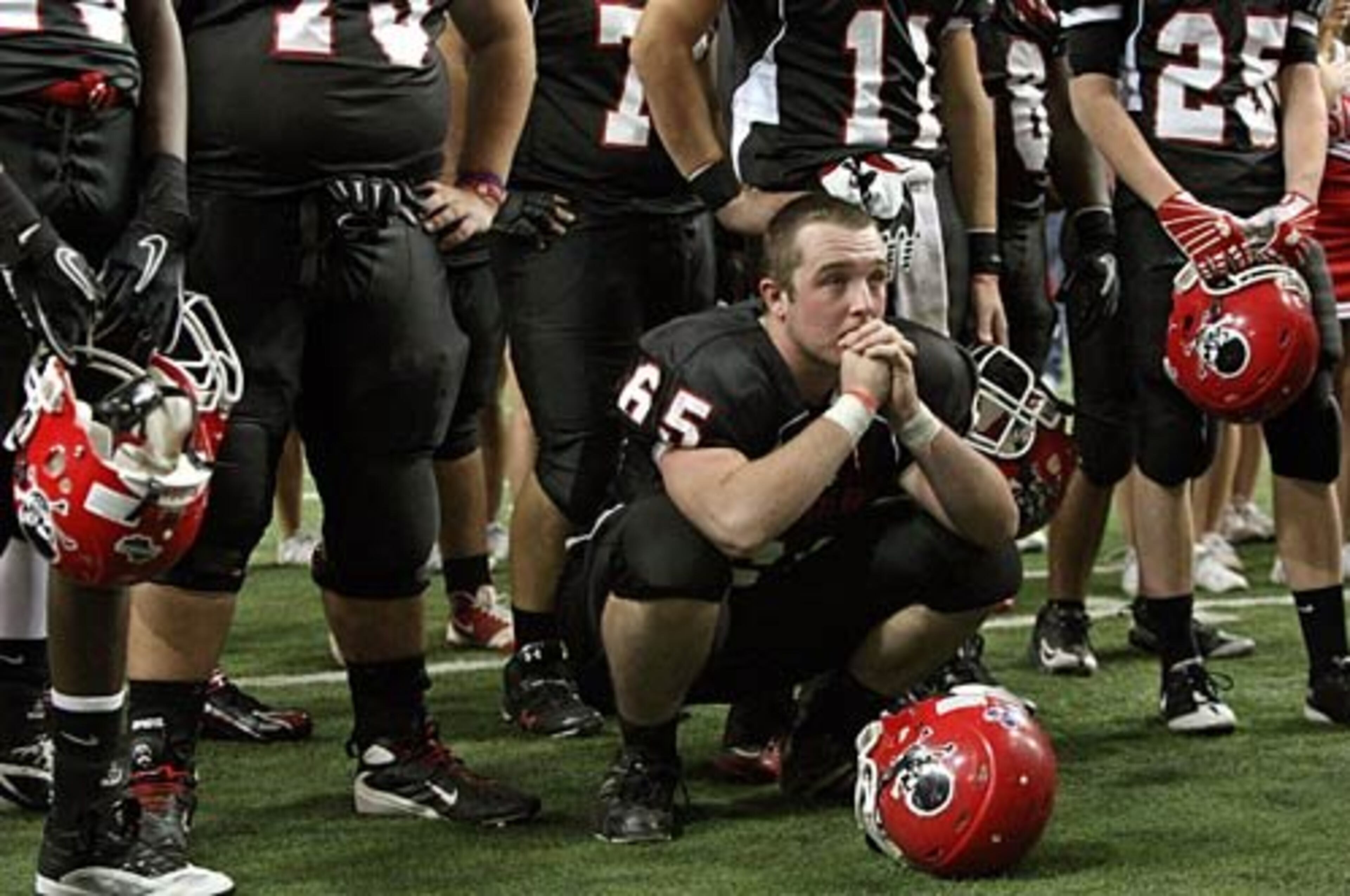 Savannah Christian lineman Phillip Abshire takes a knee with teammates as he watches Clinch County celebrate their 24-14 win over Savannah Christian in the Class A final.