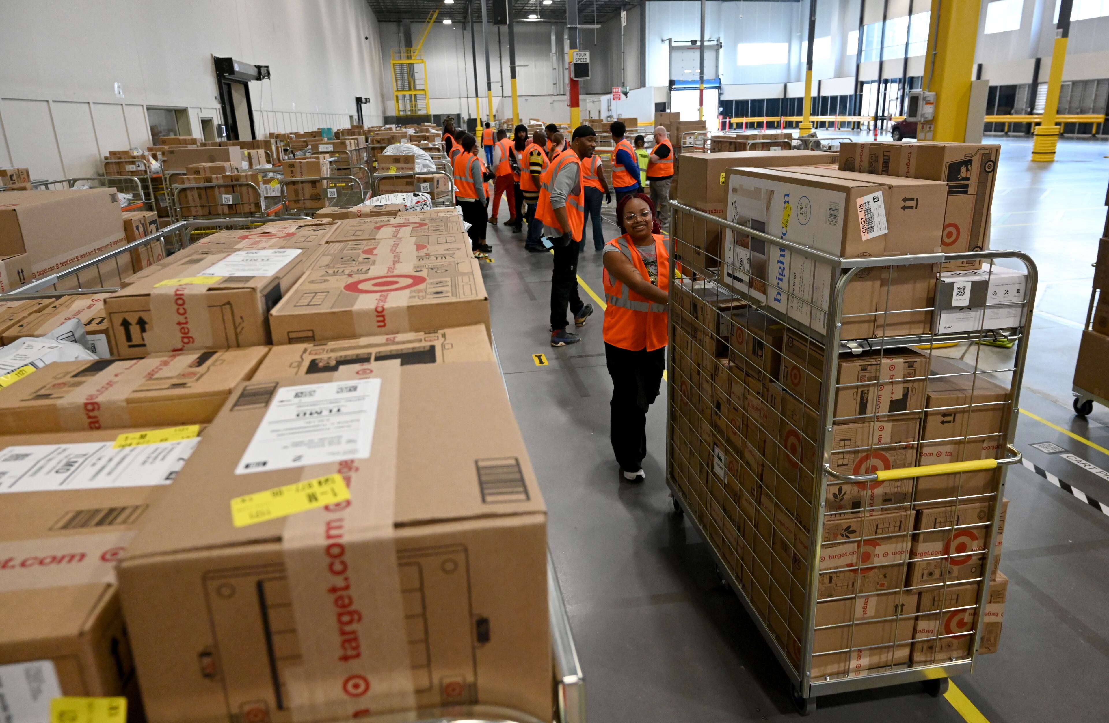 Workers prepare packages for delivery drivers at the Target sortation center in Lawrenceville on Friday, Nov. 21, 2025. (Hyosub Shin/AJC)