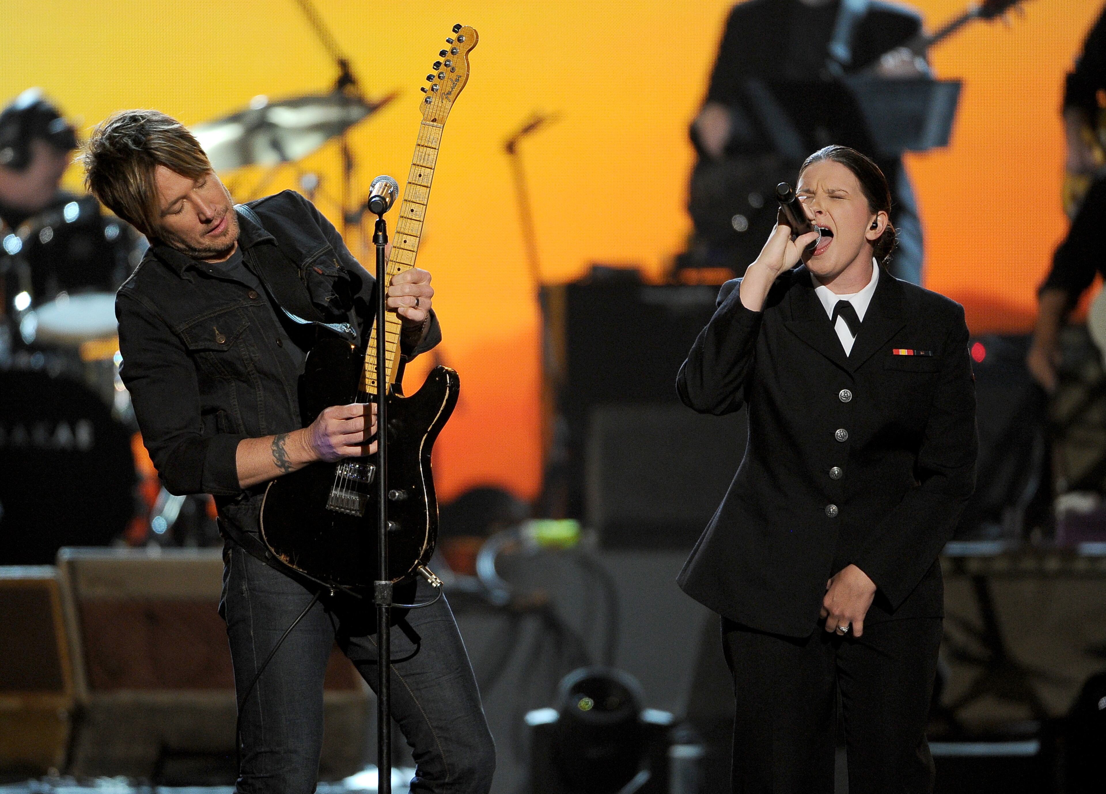 Keith Urban, left, and Destiny Mills-Coates, Petty Officer 3rd Class, perform at ACM Presents an All-Star Salute to the Troops on Monday, April 7, 2014, in Las Vegas. (Photo by Chris Pizzello/Invision/AP)