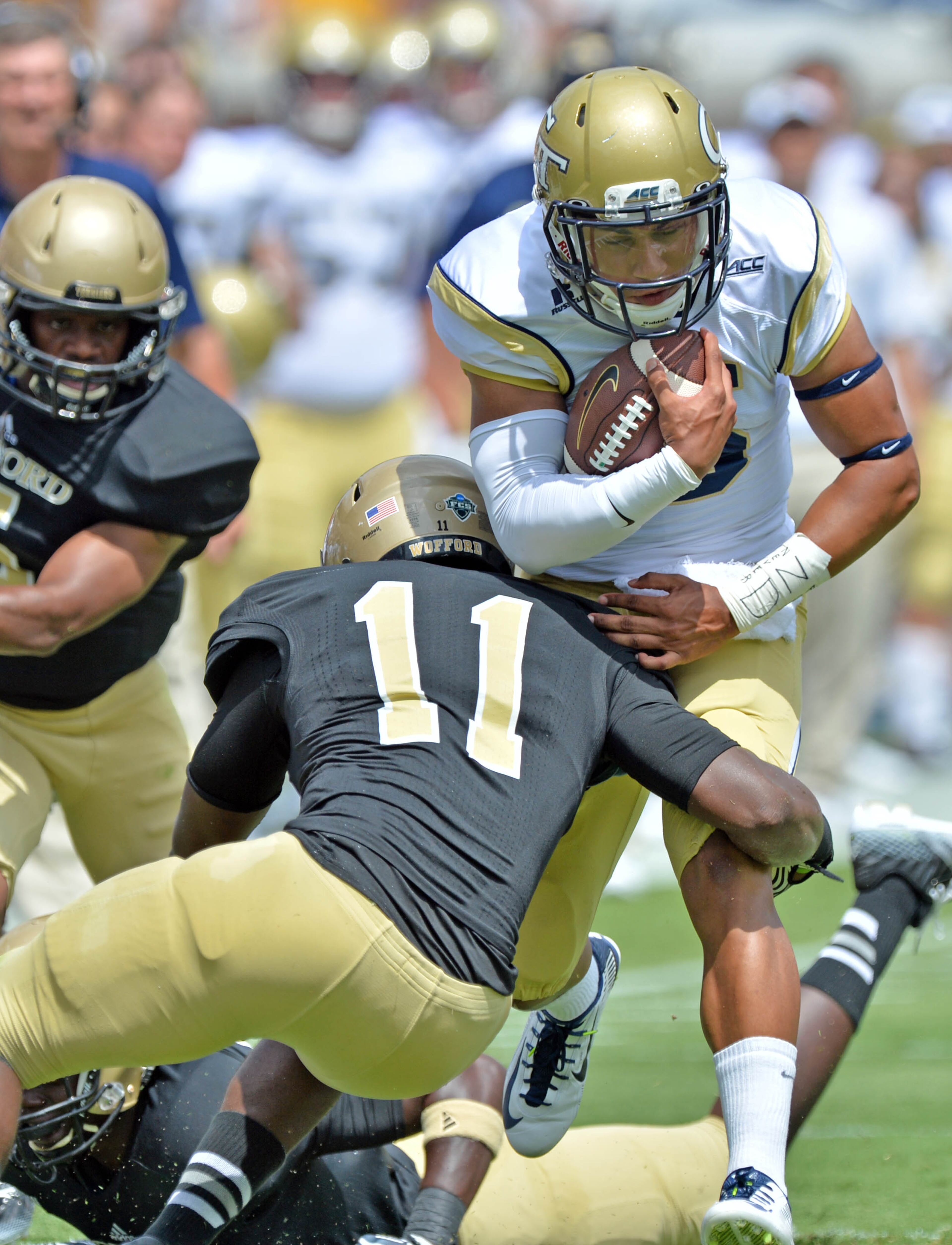 Georgia Tech Yellow Jackets quarterback Justin Thomas (5) is stopped by Wofford Terriers safety Jaleel Green (11) in the first half of the Georgia Tech season opener at Bobby Dodd Stadium on Saturday, August 30, 2014. HYOSUB SHIN / HSHIN@AJC.COM