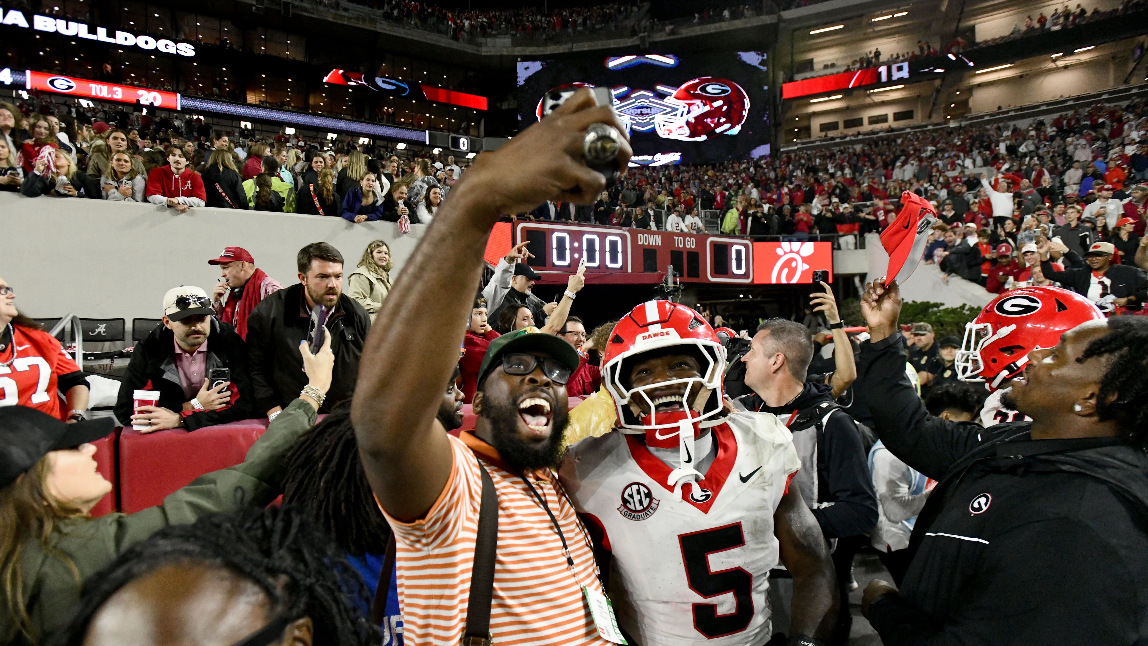 Georgia players celebrate with fans after Georgia defeated Alabama on Oct. 10, 2026, in Tuscaloosa. Georgia won 20-17. (Hyosub Shin/AJC)