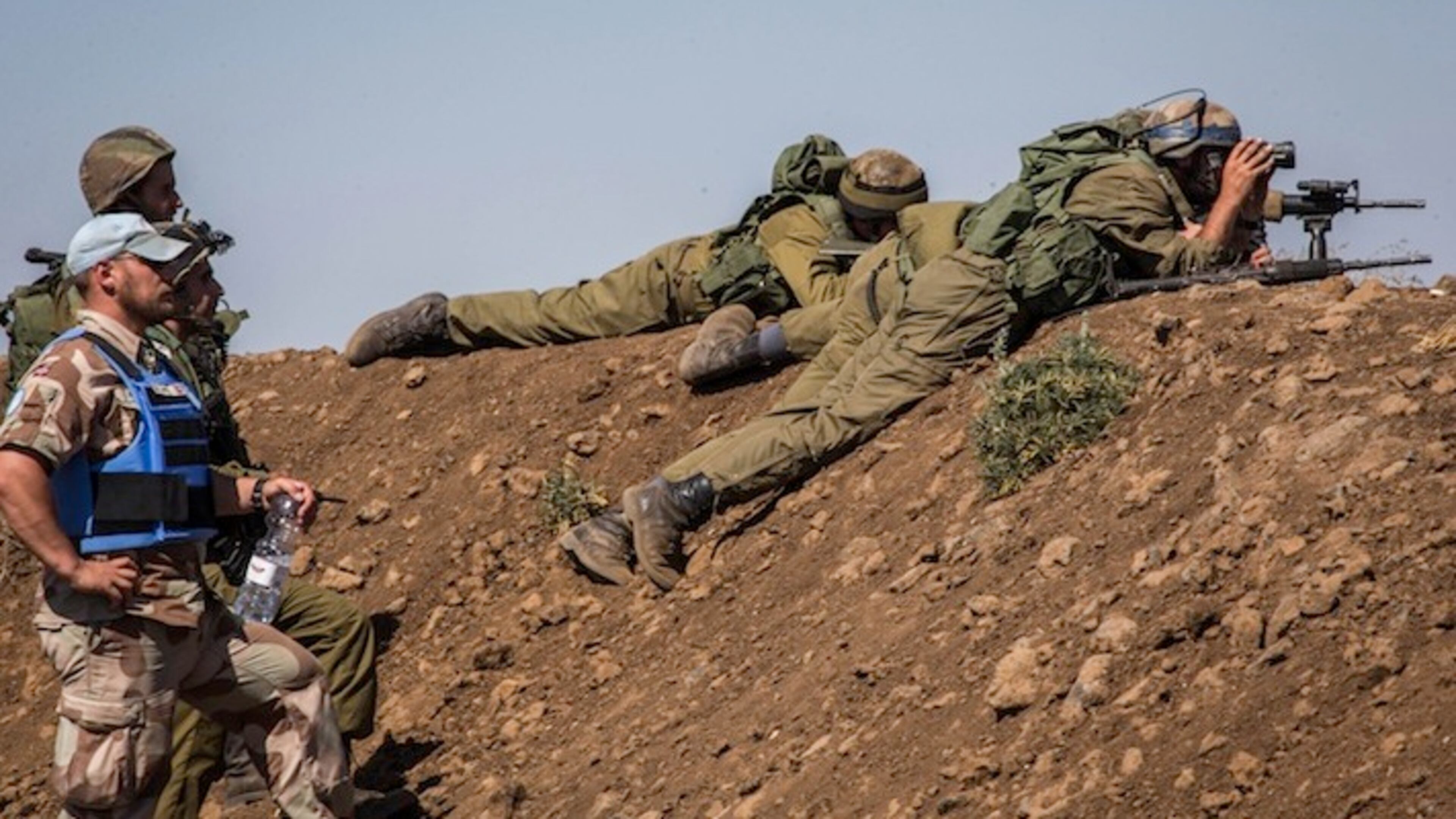 A Norwegian member of the United Nations Disengagement Observer Force stands by Israeli soldiers keeping position in the Israeli-occupied Golan Heights on Sept. 11, 2014. (Xinhua/Sipa USA/TNS)