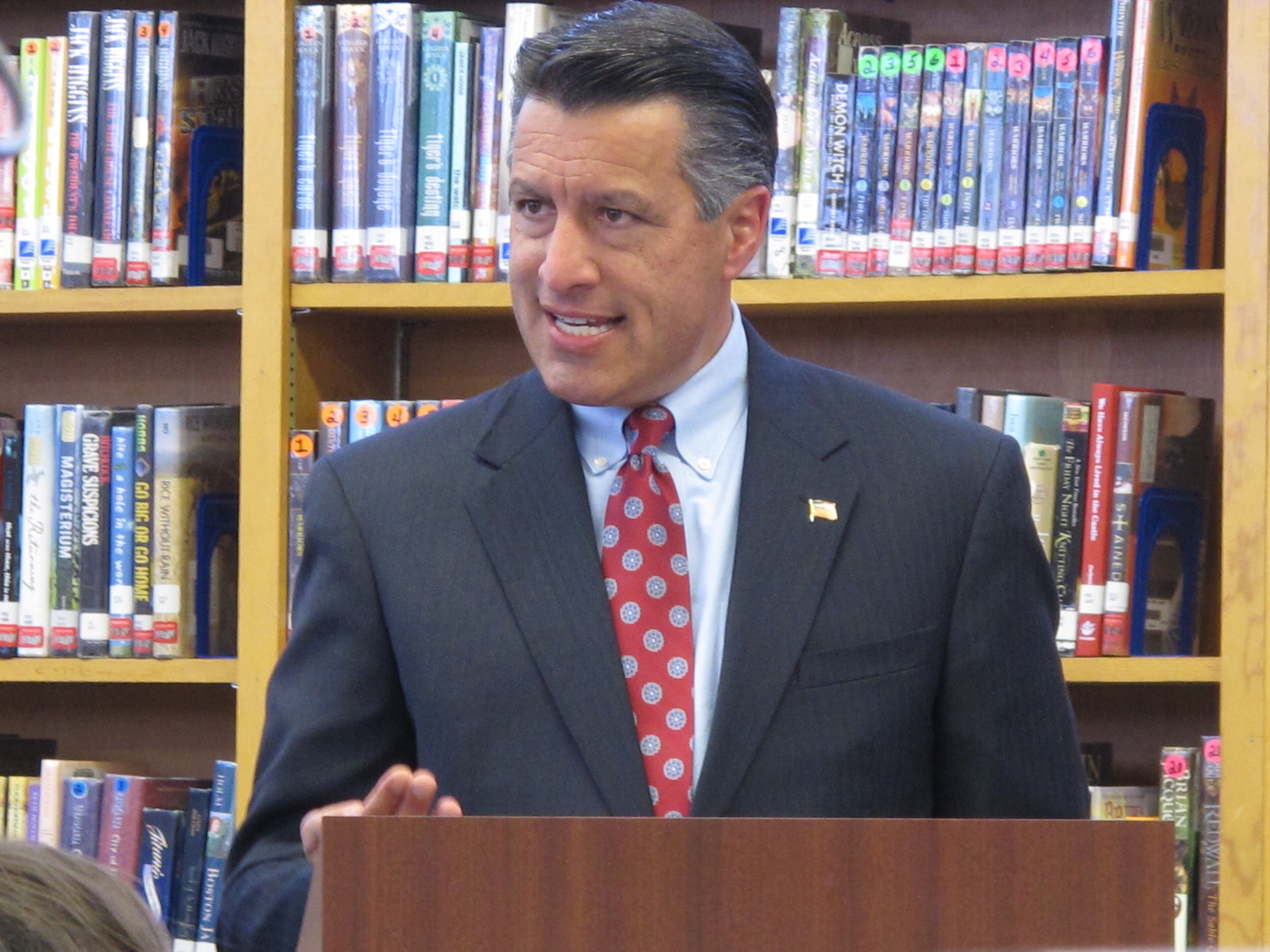 Nevada Gov. Brian Sandoval speaks to students, teachers and others in the library at Reno High School after signing into law on Monday, June 8, 2015, a measure creating millions of dollars in incentives to combat the state's teacher shortage. (AP Photo/Scott Sonner)