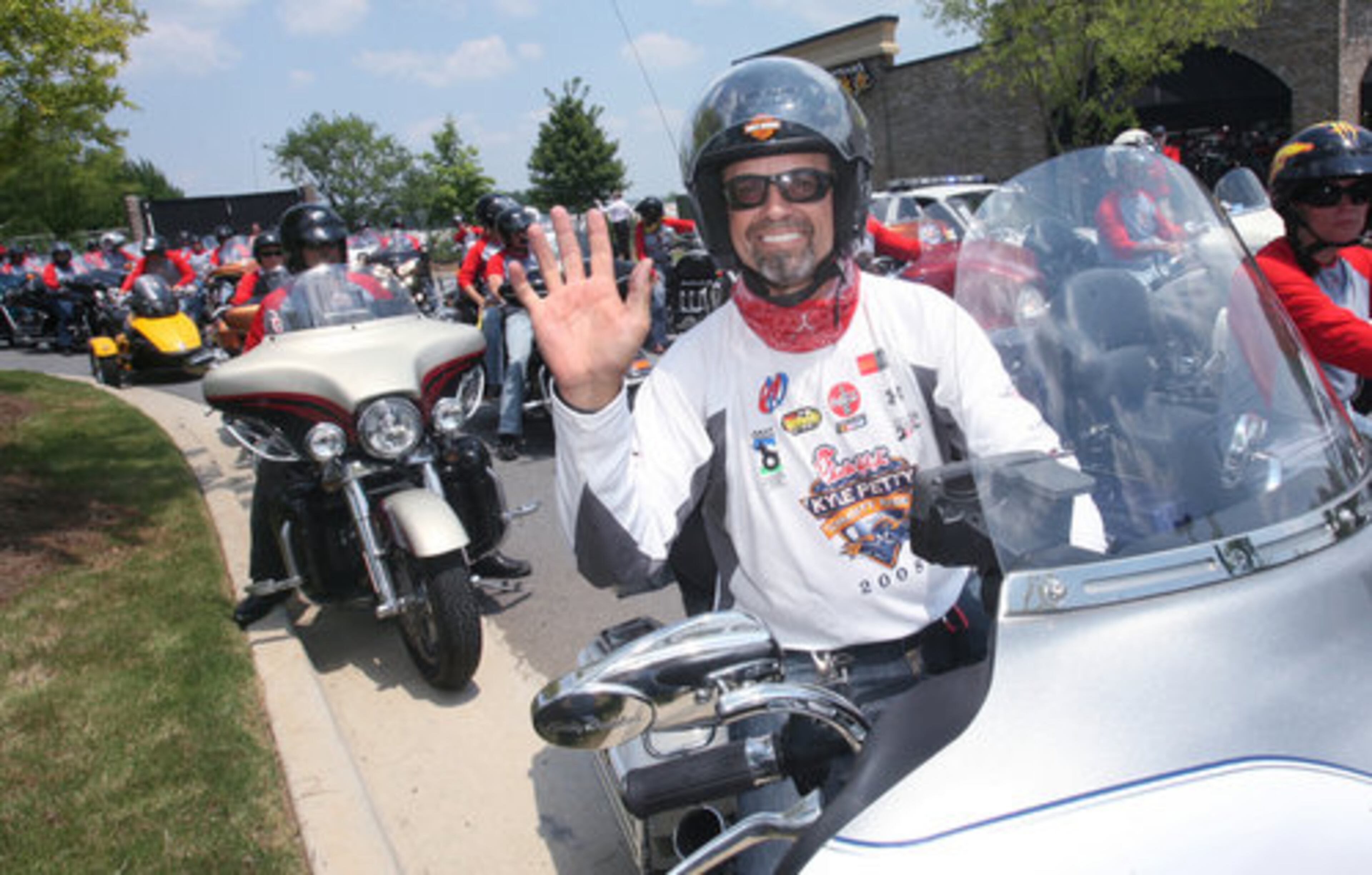 NASCAR driver Kyle Petty waves as he joins other motorcyclists in the Chick-fil-A Kyle Petty Charity Ride following a splash of gas at the Race Trac station on Hwy 317/ Lawrenceville-Suwanee Road on Friday.